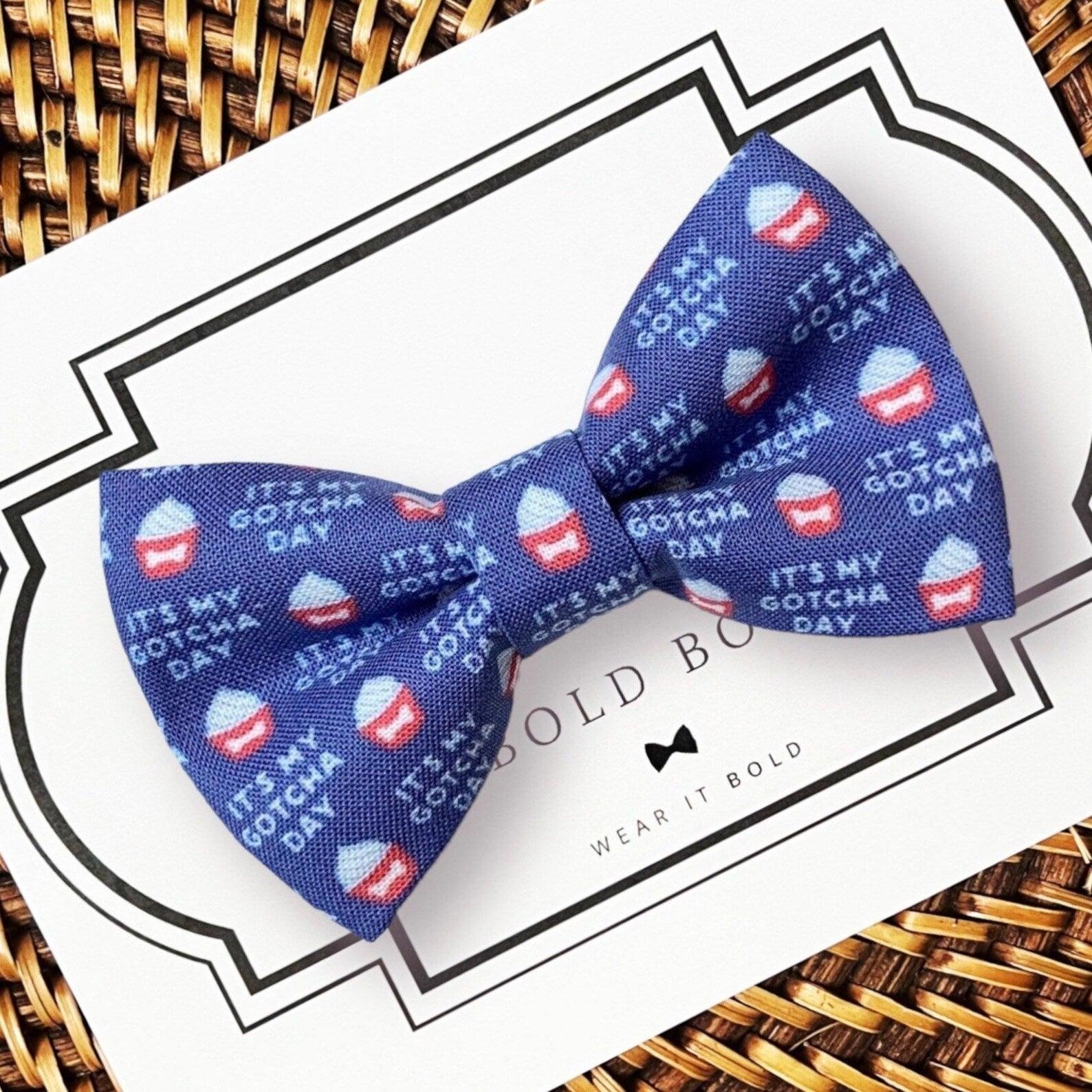 a blue dog bow tie with red, white and blue cupcakes on it that says “It’s my gotcha day”