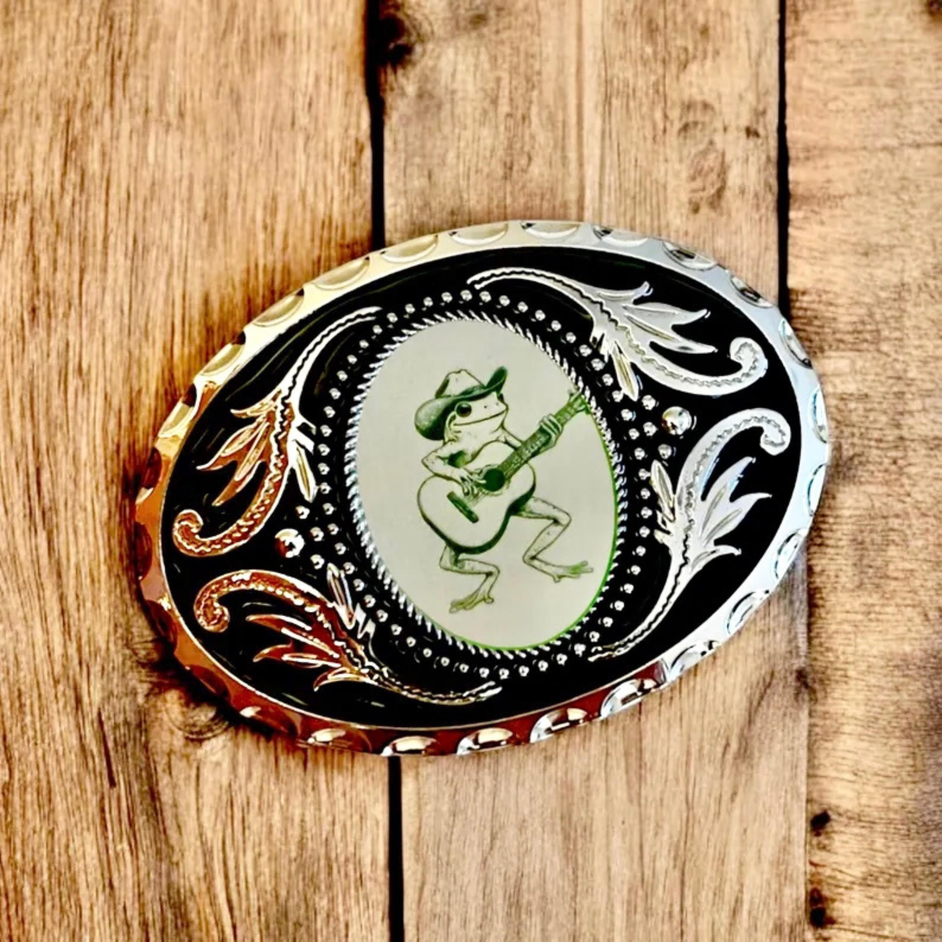 Silver Belt Buckle with green frog, Western Cowboy Accessory on wood table