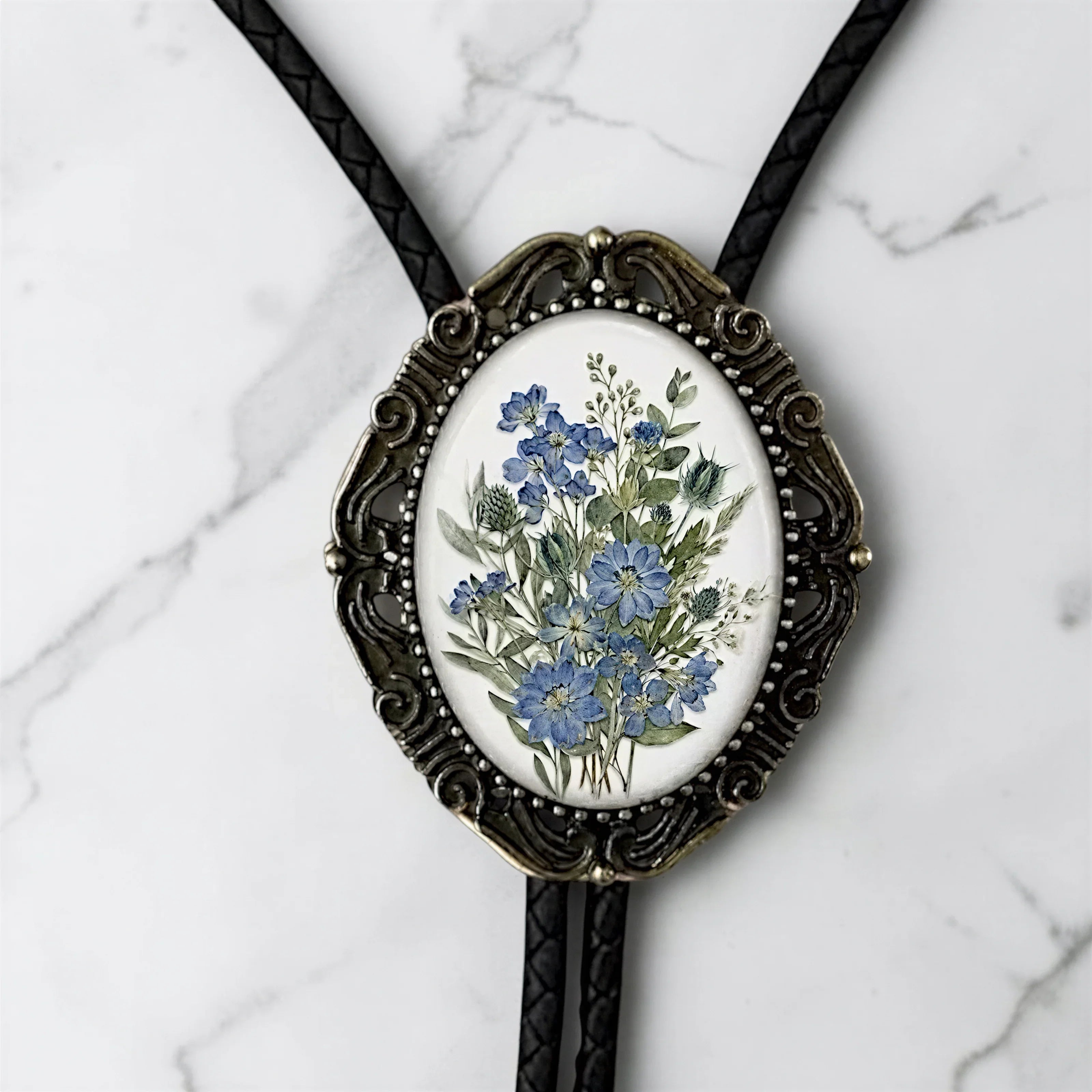 Bolo tie for men and women with dusty blue flowers.