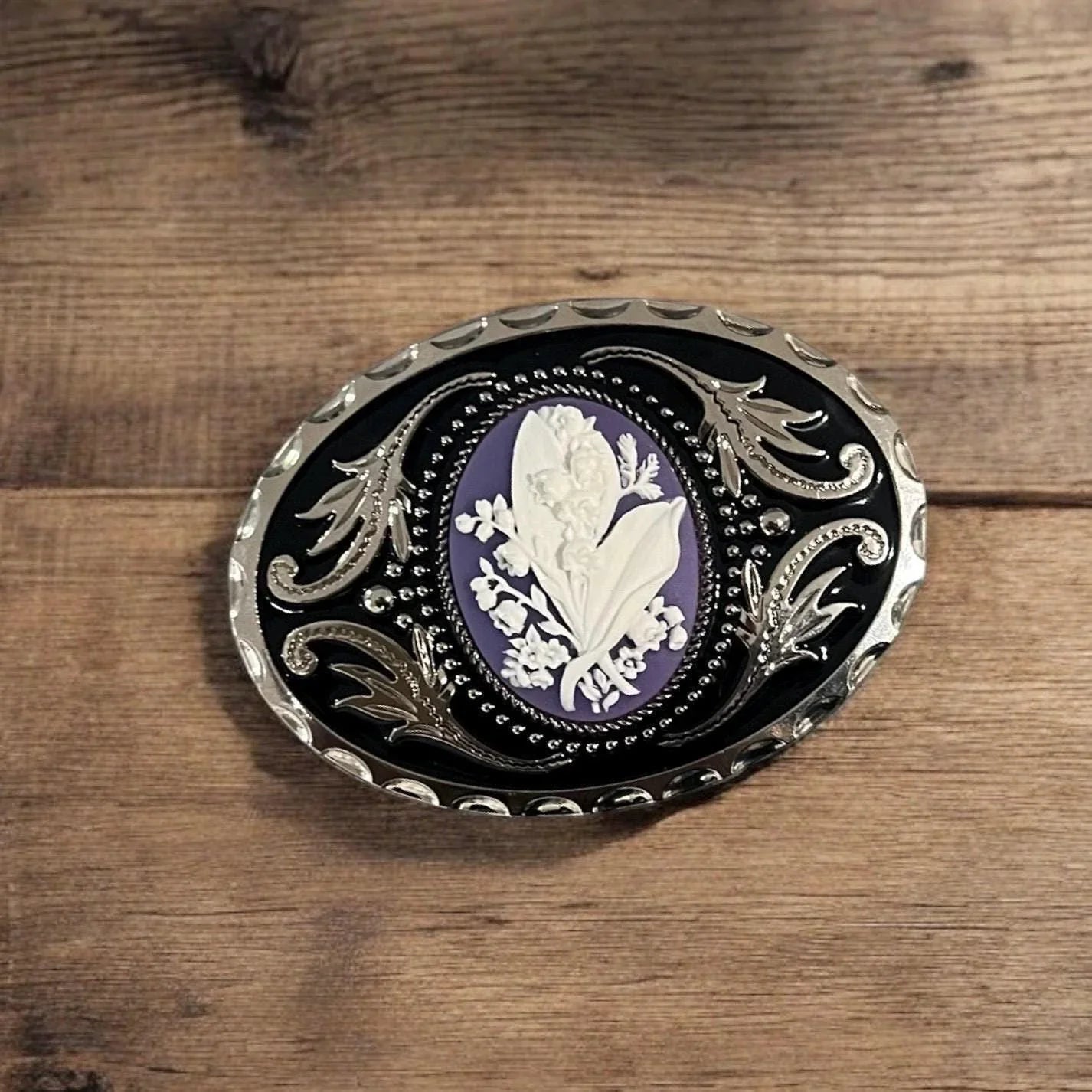 Two options for belt buckles: Option 1 has a leaf pattern and option 2 has flowers on it