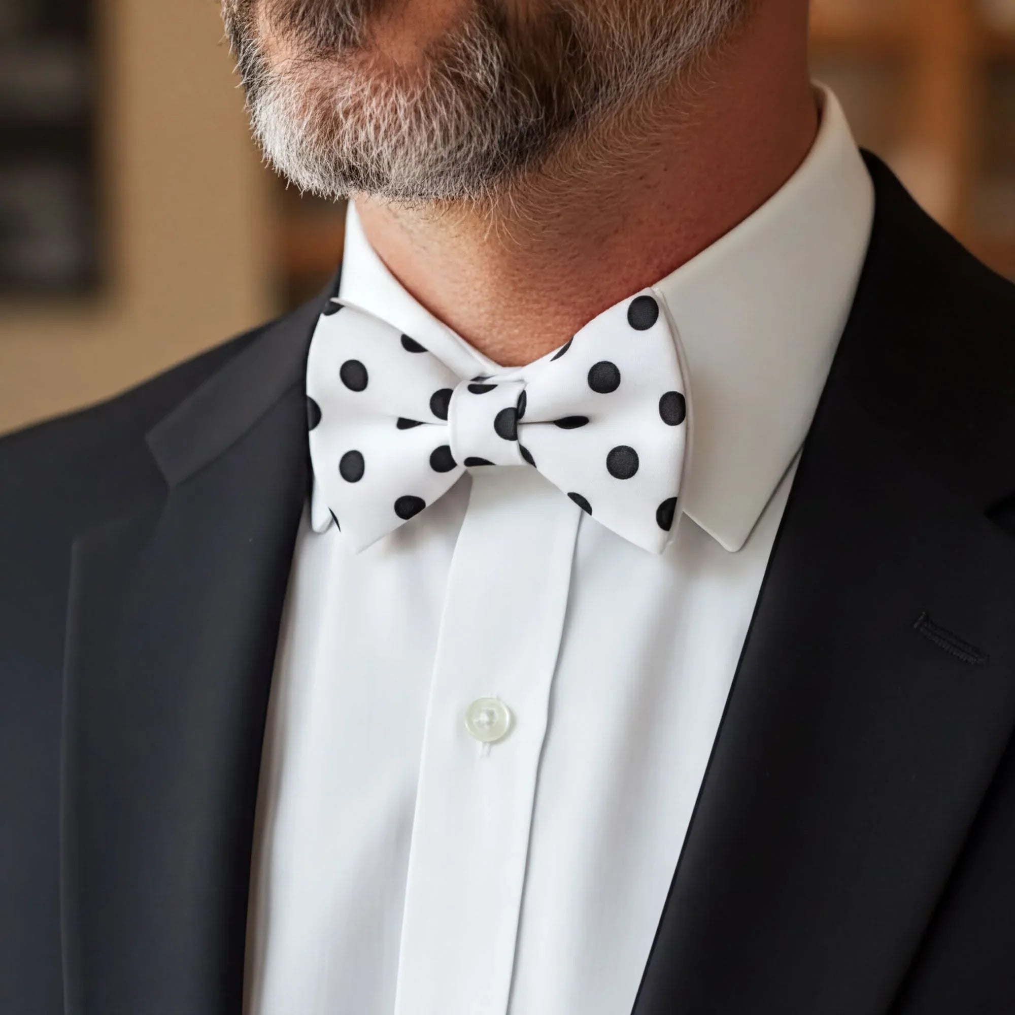 Polka dot bowtie on a man in a suit.