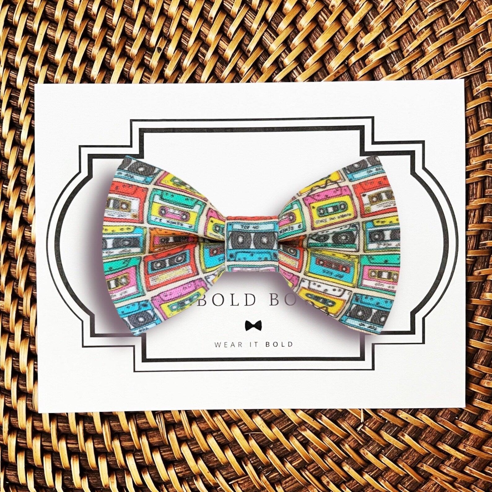 Dog bow tie size chart. Size Small is 3 1/2 inches wide for small dogs under 15 lbs. Size Medium is 4 inches wide for medium dogs between 15 band 40 lbs. Size Large is 4 1/2 inches wide for Large Dogs between 40 band 80 lbs. Size Extra Large is 5 1/2 inches wide for Extra Large Dogs over 80 lbs. Sizing is up to preference and pet bow ties slide on to dog collars with elastic.