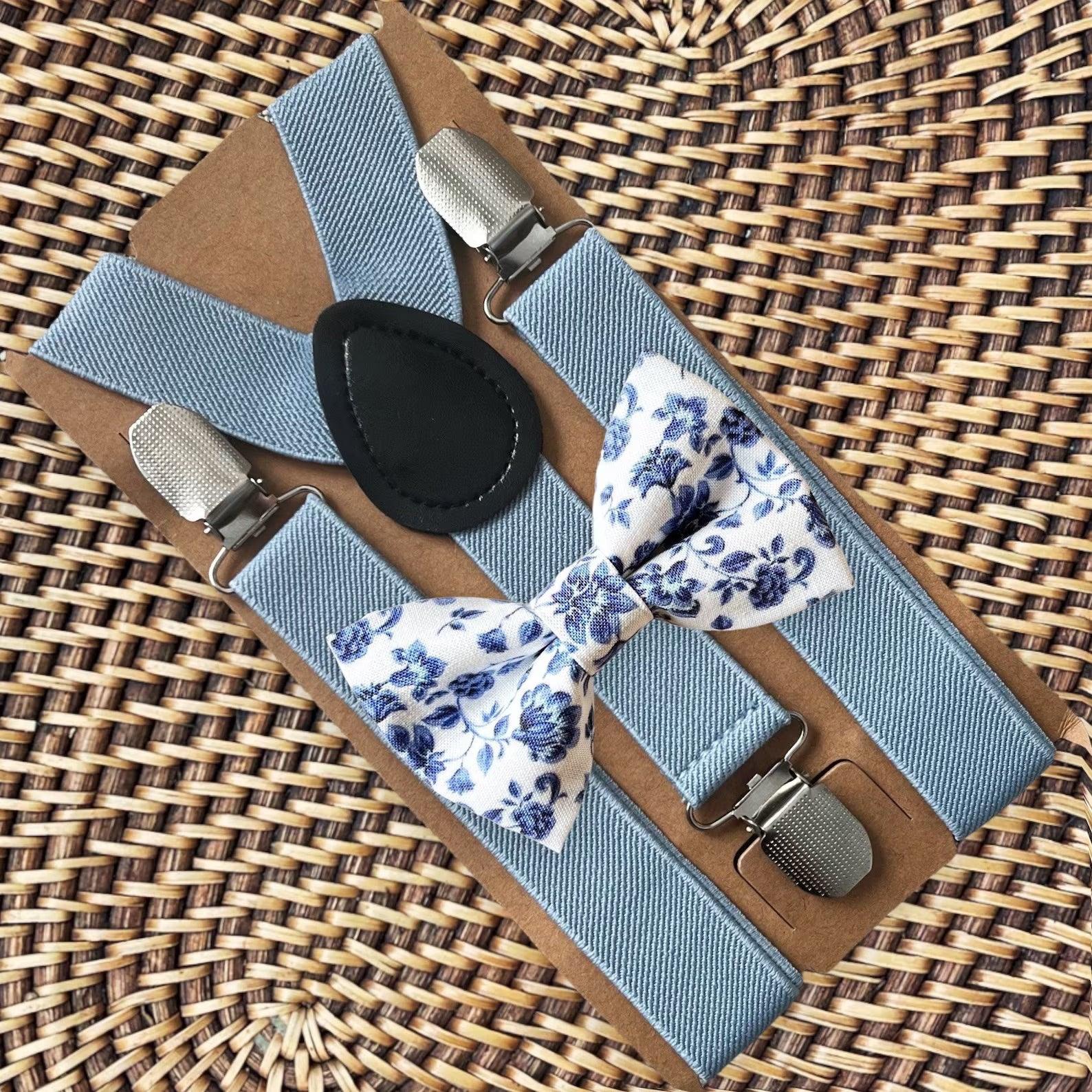 Dusty blue and white floral bow tie and dusty blue suspenders for a wedding, groomsmen, and ring bearer outfit.