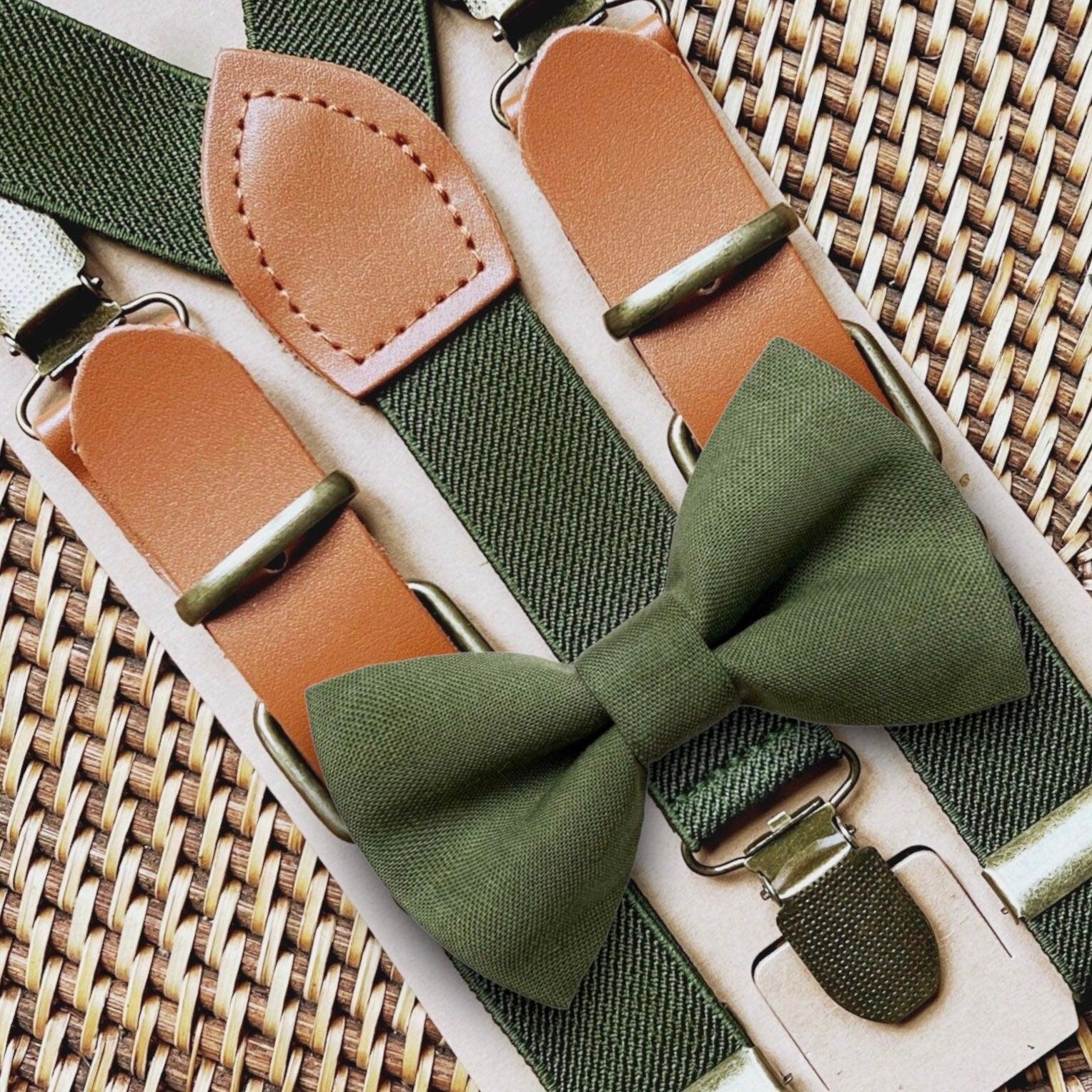 Close up of olive bow tie and matching olive buckle suspenders with tan leather patches on a woven background.