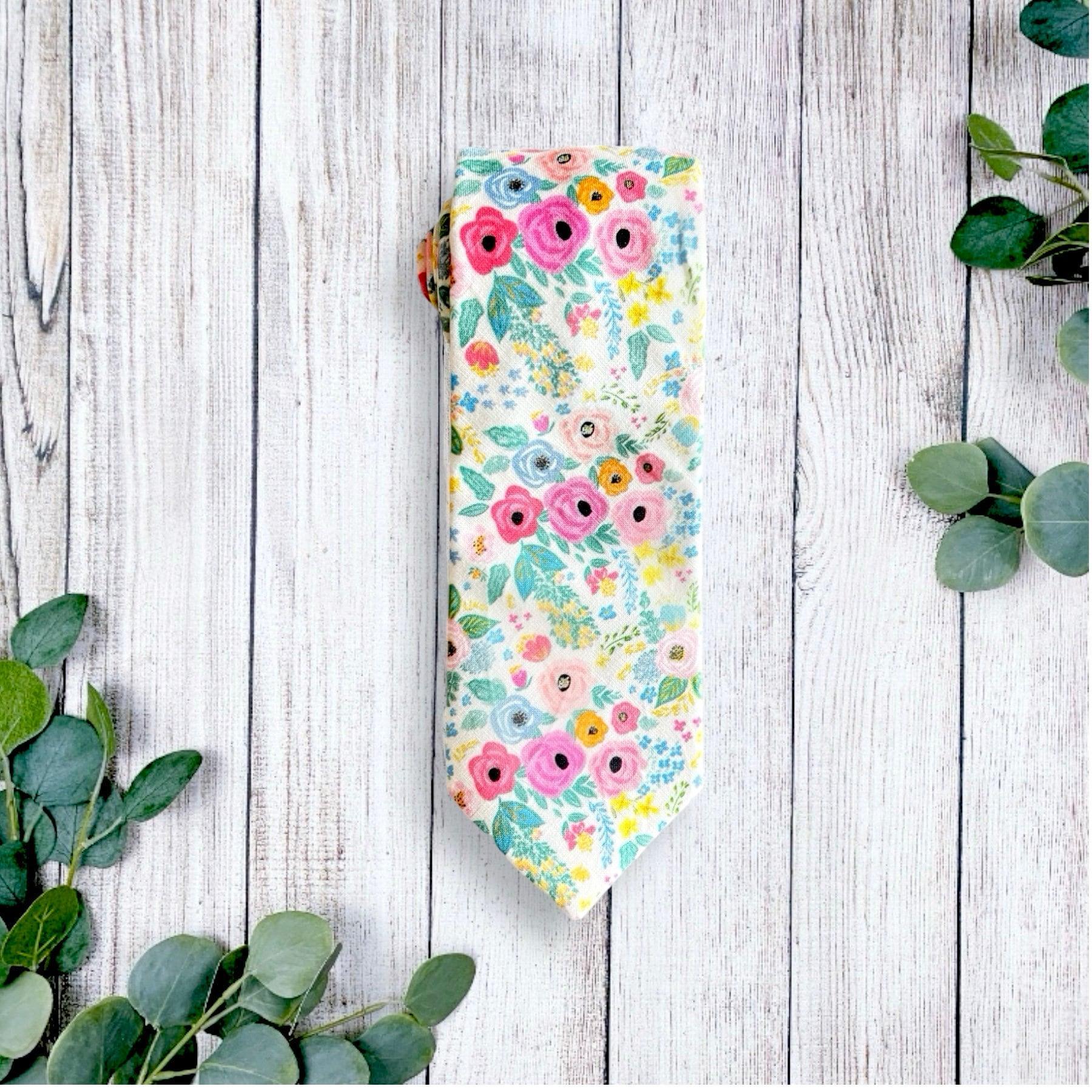 Floral Wonderland Garden bow tie shown on light wooden planks from a top view