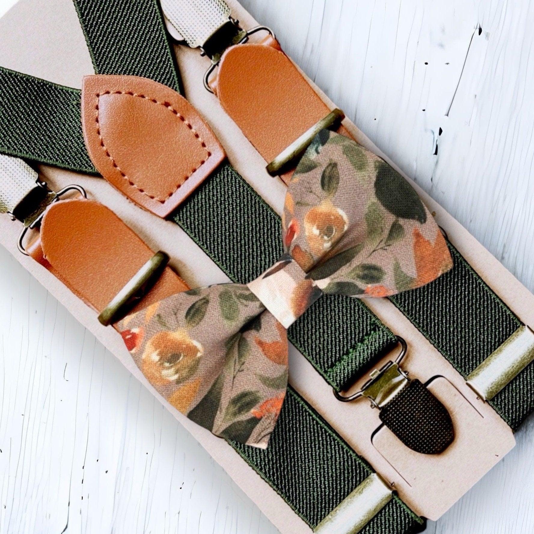 Close up of taupe autumn floral bow tie and olive buckle suspenders with tan leather attachments.