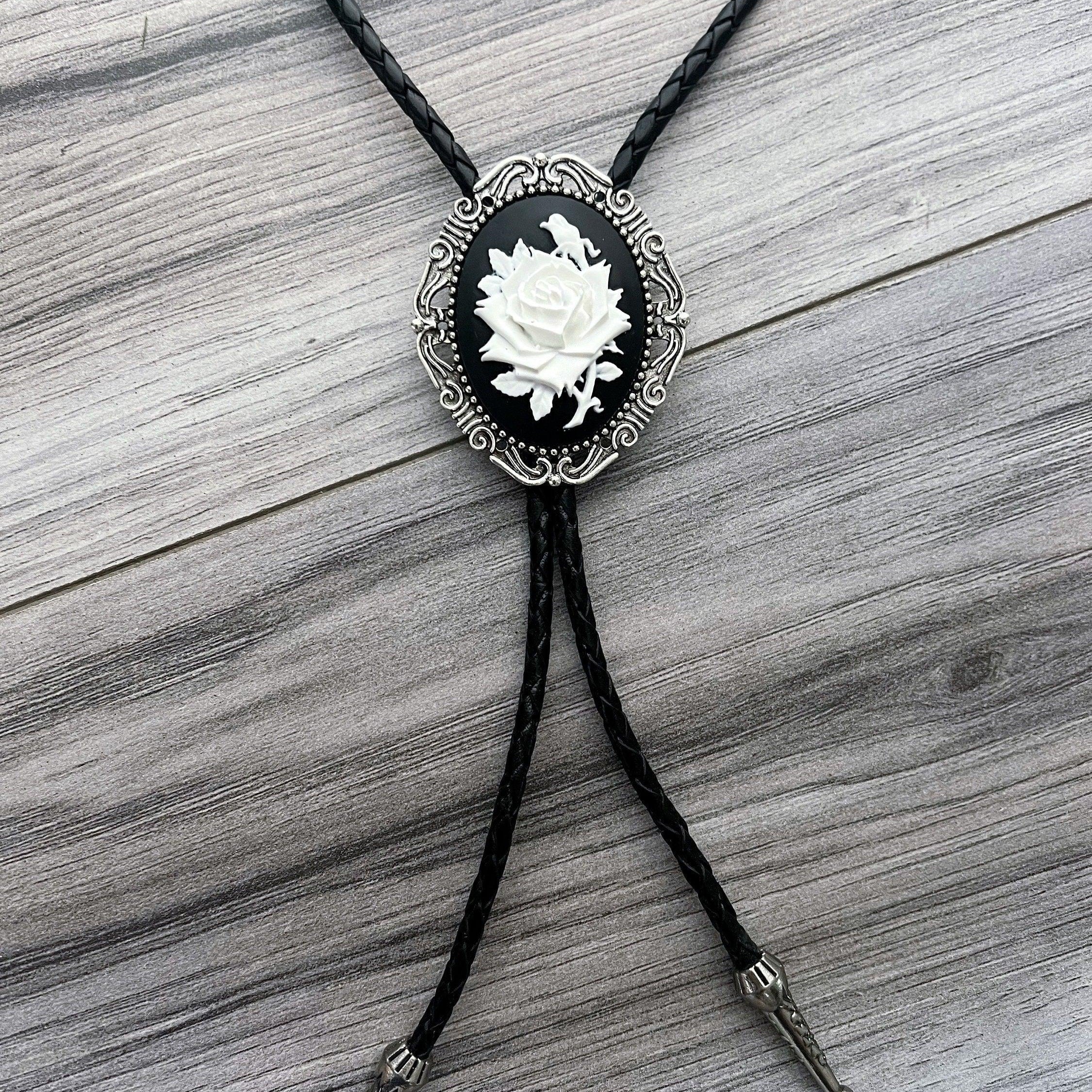 Silver back of a bolo tie with a clamp on a black leather cord