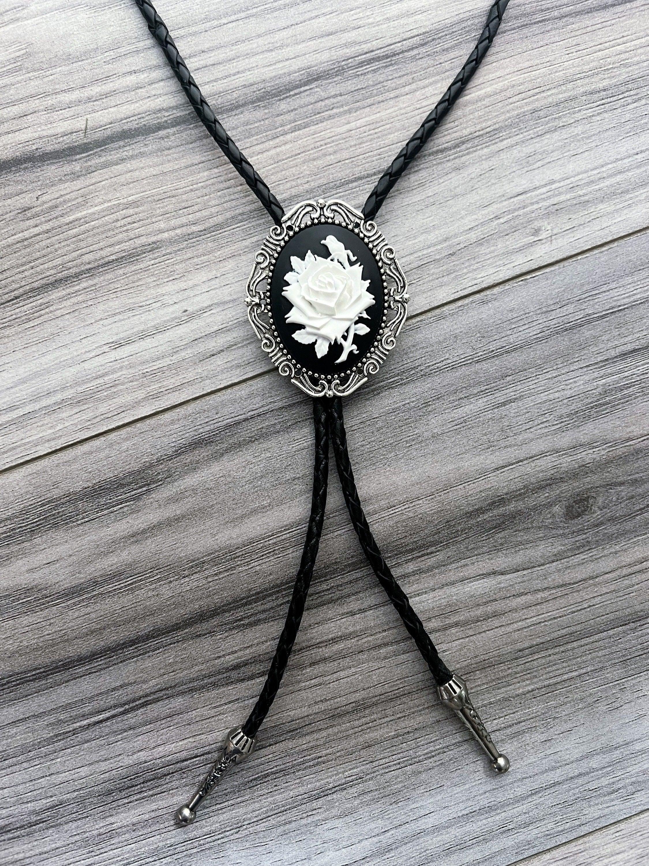 Silver back of a bolo tie with a clamp on a black leather cord