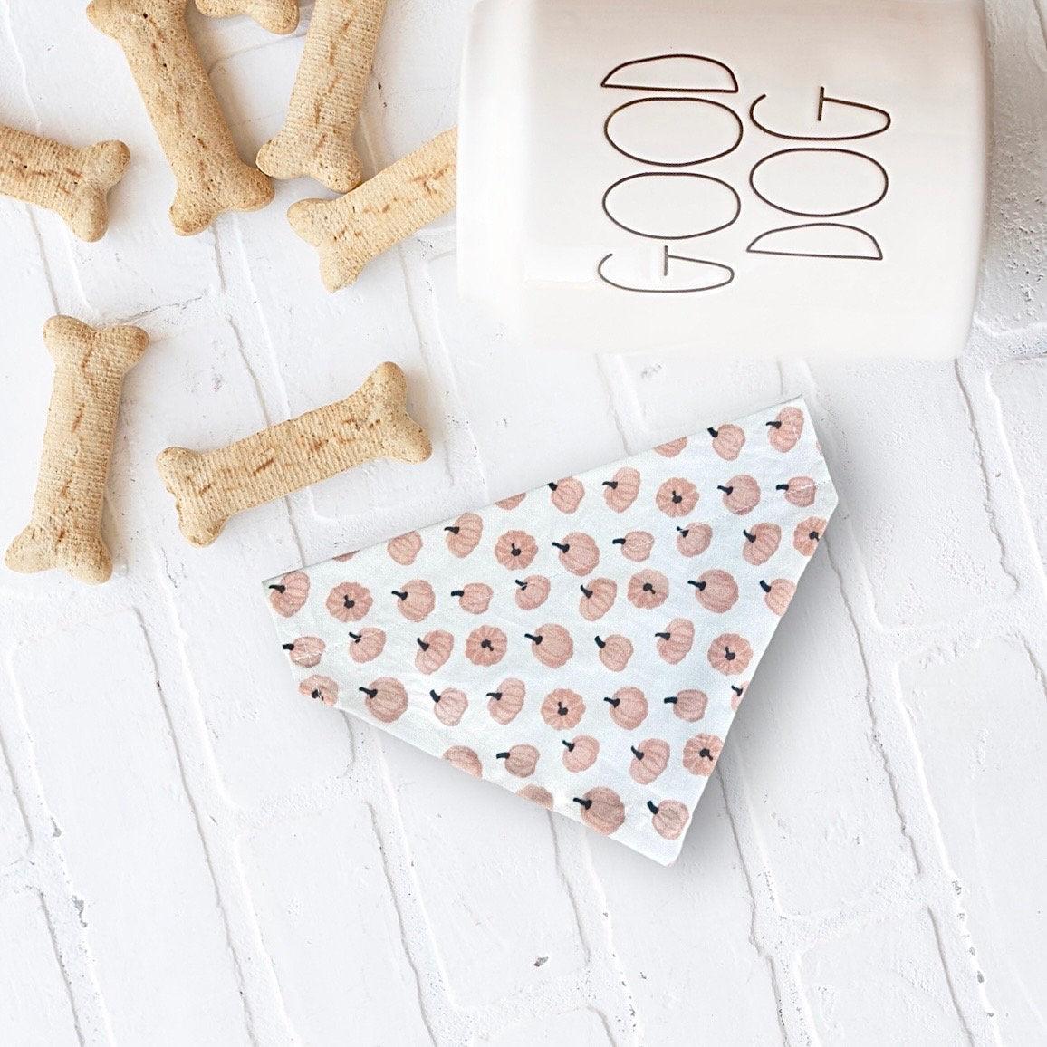 Fluffy tan dog wearing a handmade Stud Muffin dog bandana from The Bold Bow Tie, with product features including handmade design, comfortable collar slide-on fit, high-quality fabric, and sizes for all breeds.