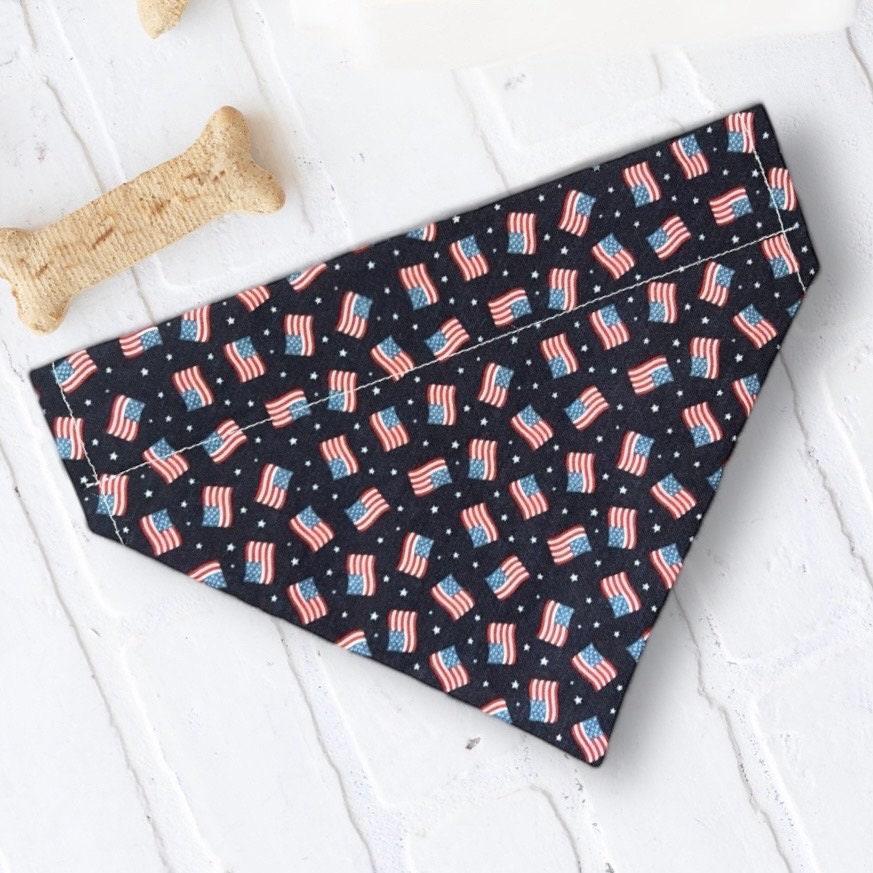 American flag dog bandana laid flat on a light surface with a bone toy nearby