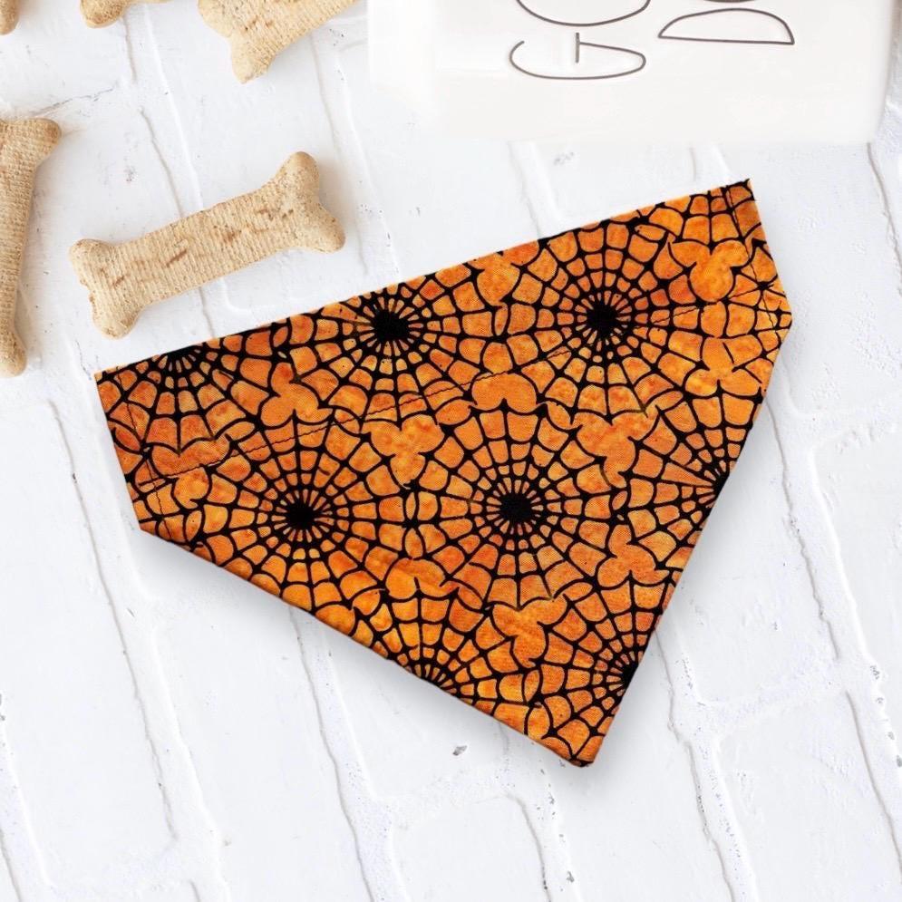 Orange and black Halloween spiderweb bandana for dogs or cats laid flat
