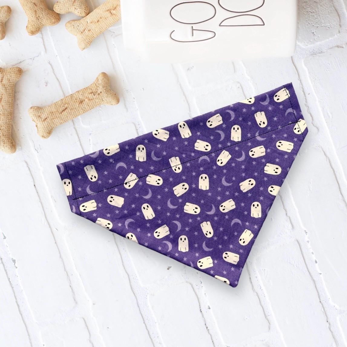 Purple Halloween bandana with white ghost designs laid flat