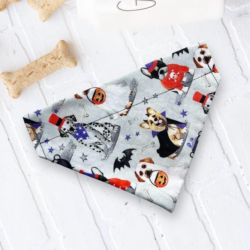 Trick or Treat puppy bandana in light gray with Halloween print featuring pumpkins dogs and bats laid flat