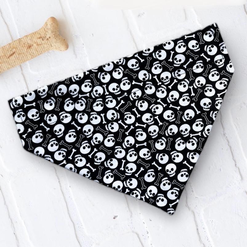 Black fabric bandana covered in white skulls and bones Halloween pattern