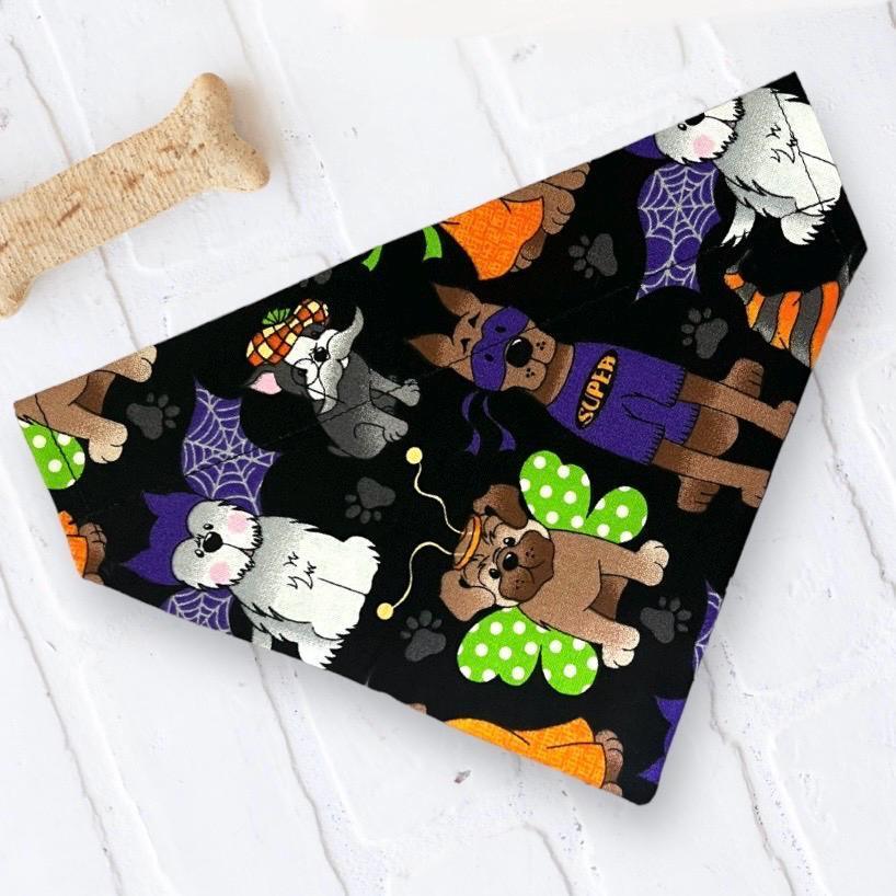 Colorful Halloween dog bandana pattern on a black background with cartoon dogs and bones