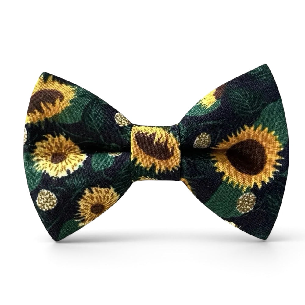 The Bold Bow Tie pre-tied cotton bow tie featuring a vibrant sunflower floral pattern on a dark green background.