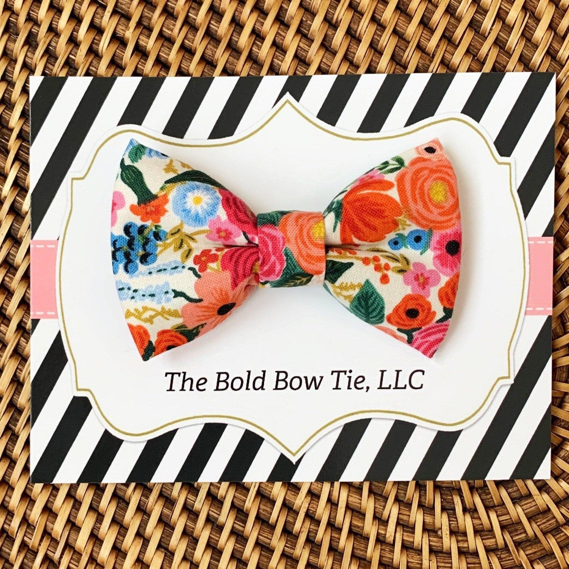 Pink and orange floral bow on a white card with bold striped packaging from The Bold Bow Tie LLC