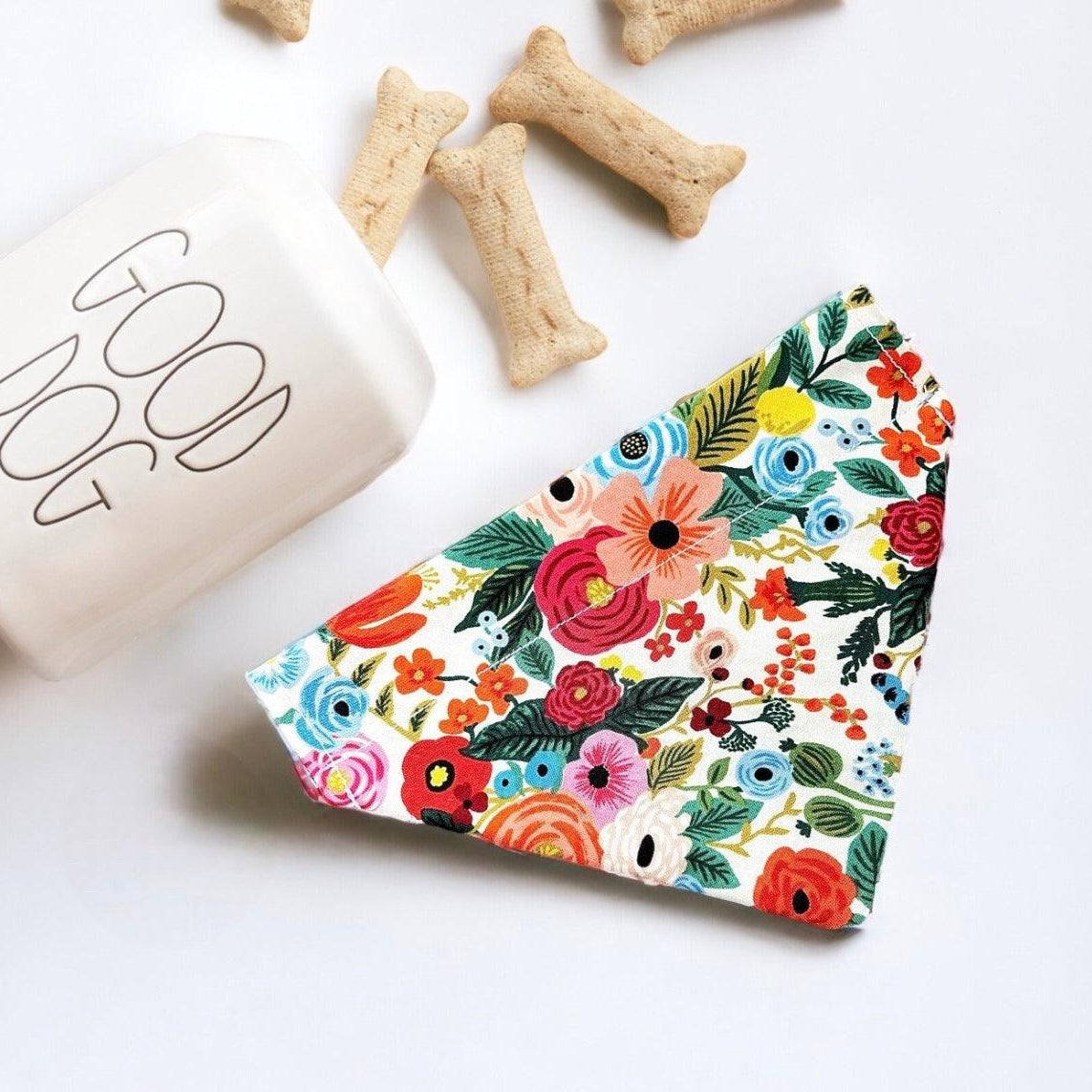 a dog bone bone next to a colorful floral napkin