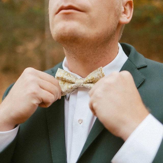 Gold bow tie on a groomsman in a wedding.