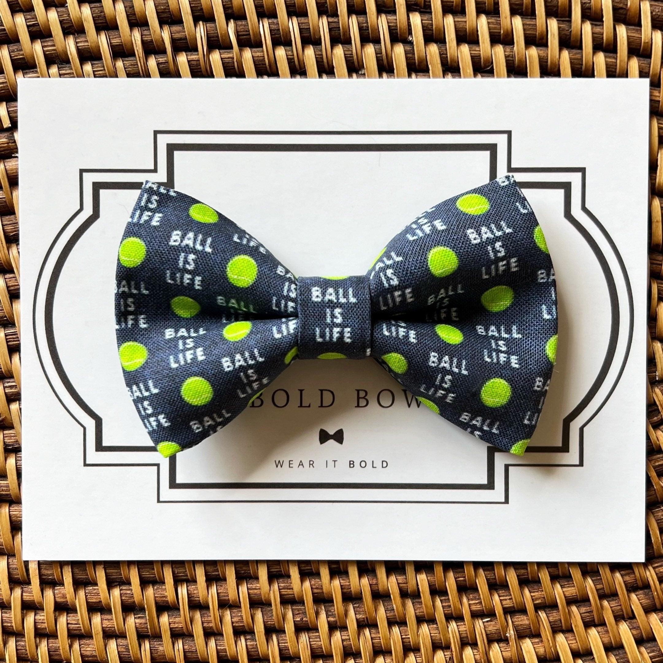 Navy bow tie with lime green polka dots on white card packaging for The Bold Bow Tie gift set