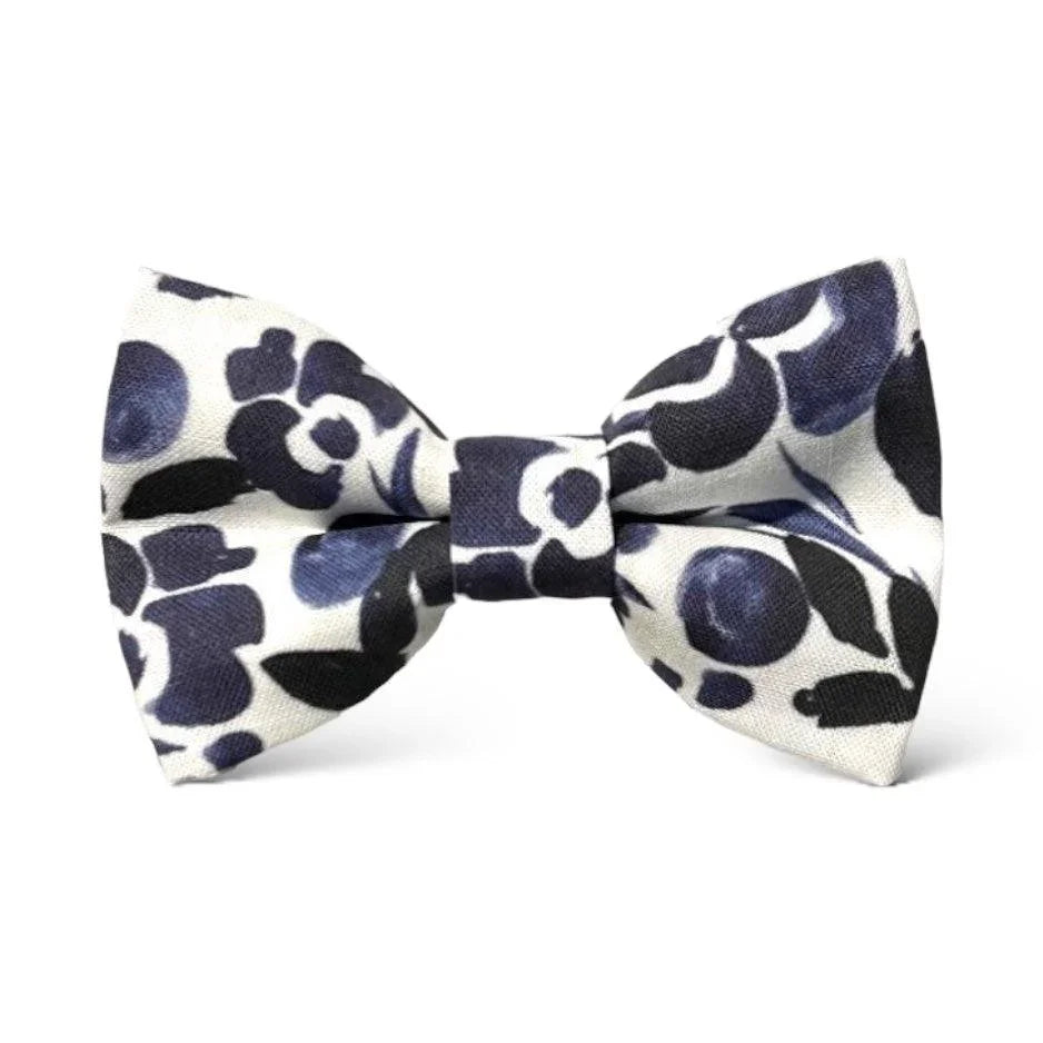 Size chart for pre-tied bow ties from The Bold Bow Tie detailing measurements across three sizes. Small is 3.5 inches wide and recommended for ages 6 months to 5 years. Medium is 4 inches wide and recommended for ages 6 to 12 years. Large is 4.5 inches wide and recommended for ages 13 years and up. Visual icons illustrate the relative sizes with horizontal arrows showing that width is measured from wingtip to wingtip. Bottom text notes that all bow ties are pre-tied and ready to add to your outfit.