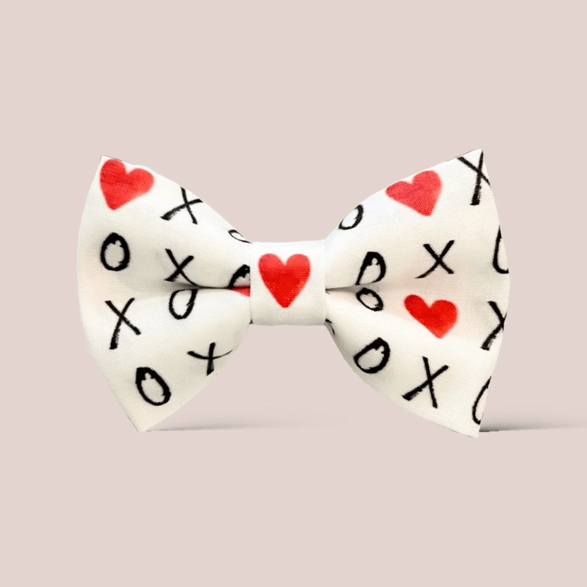 Valentines Day Hair bow with red hearts and black 'XO' pattern on a white background