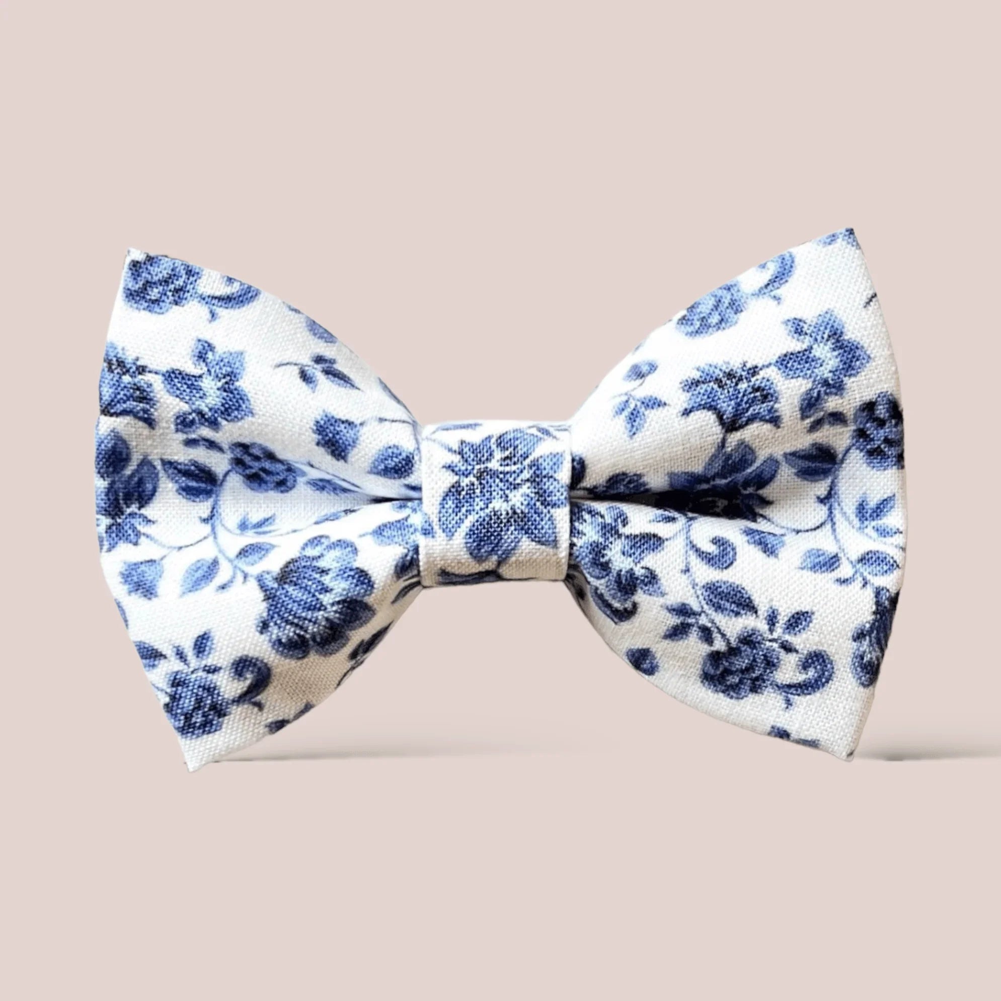 French blue floral hair bow in white fabric with blue blossoms against a beige background