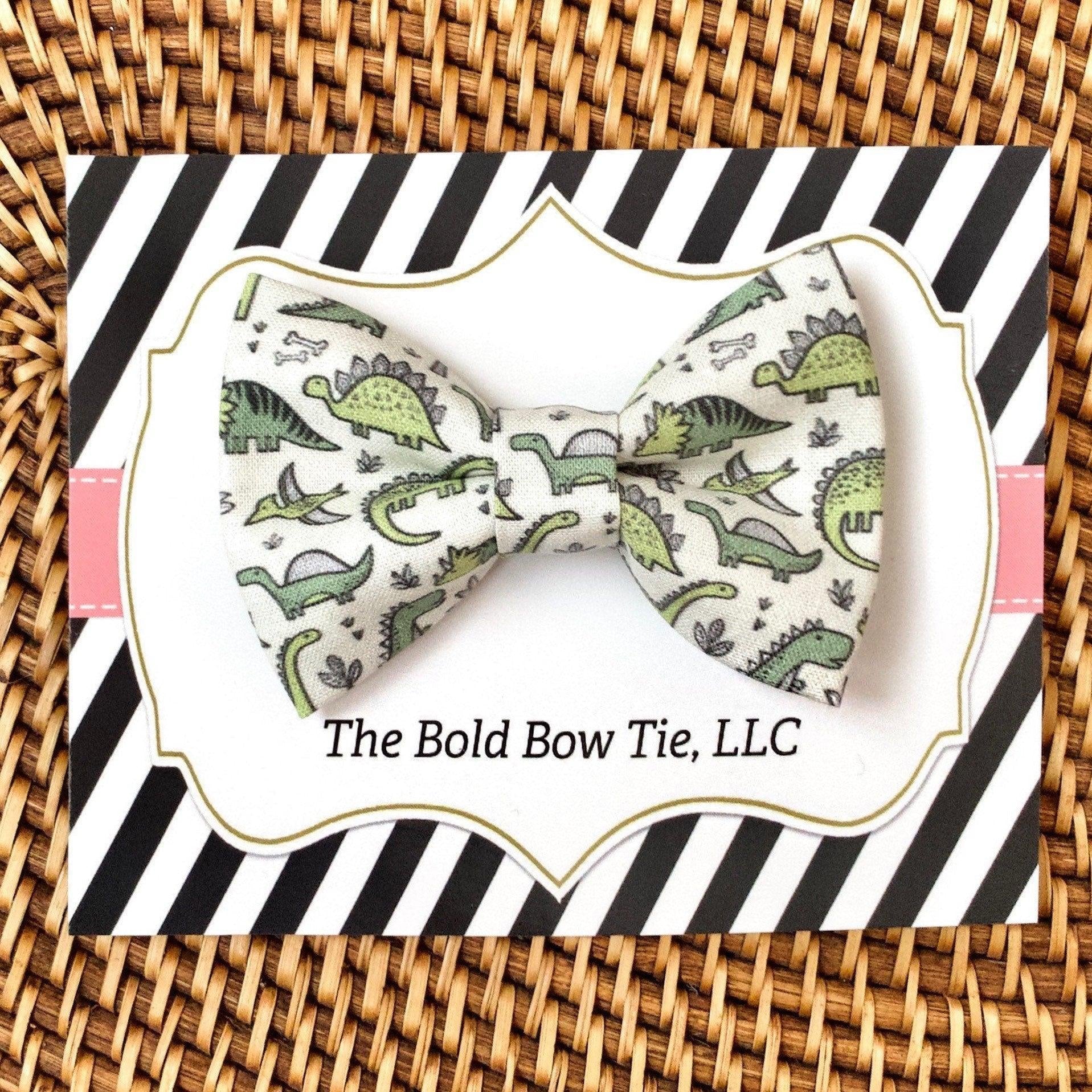 Beige dinosaur print bow tie on a striped gift card backdrop