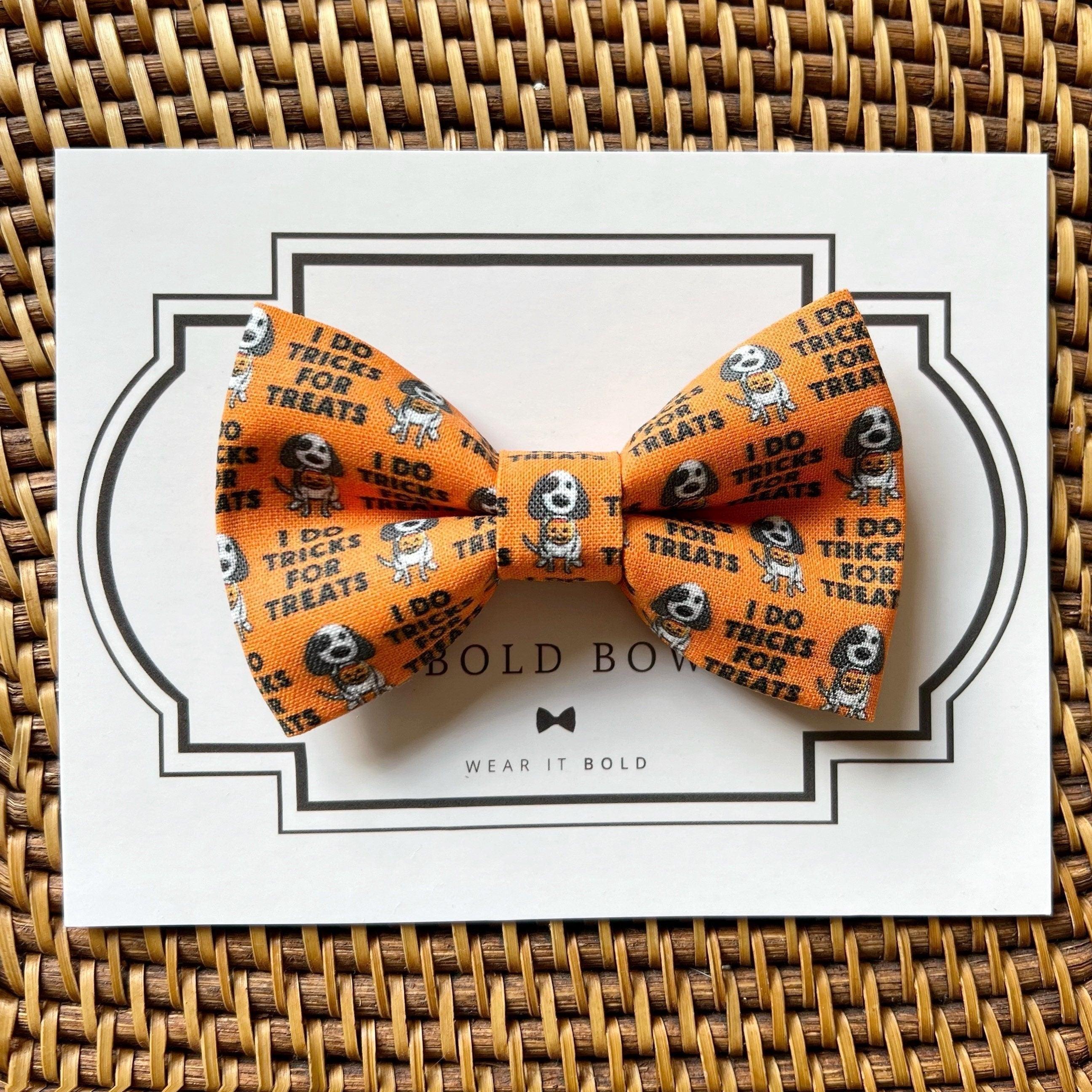 Orange Halloween bow tie with ghost images and I do trick or treat text on packaging.