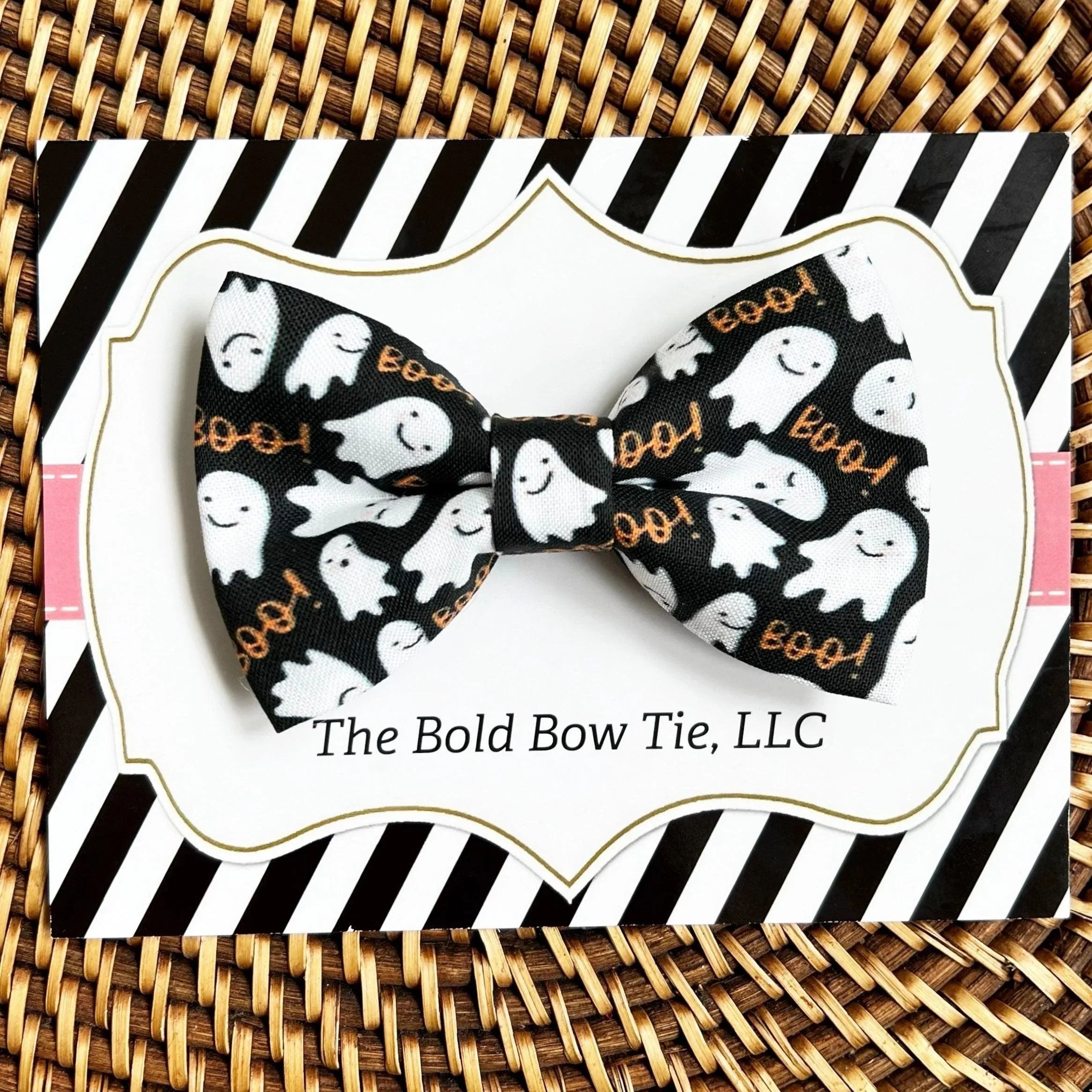 Black ghost print bow tie with orange text on a white gift card packaging with striped border.