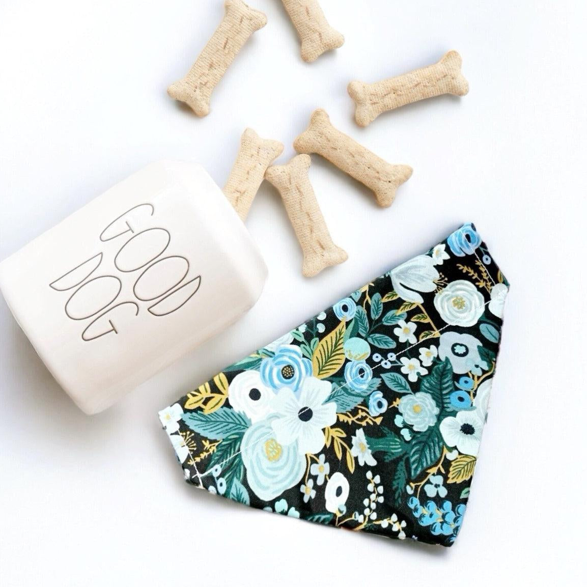 a dog bandana next to a bone bone and a dog treat