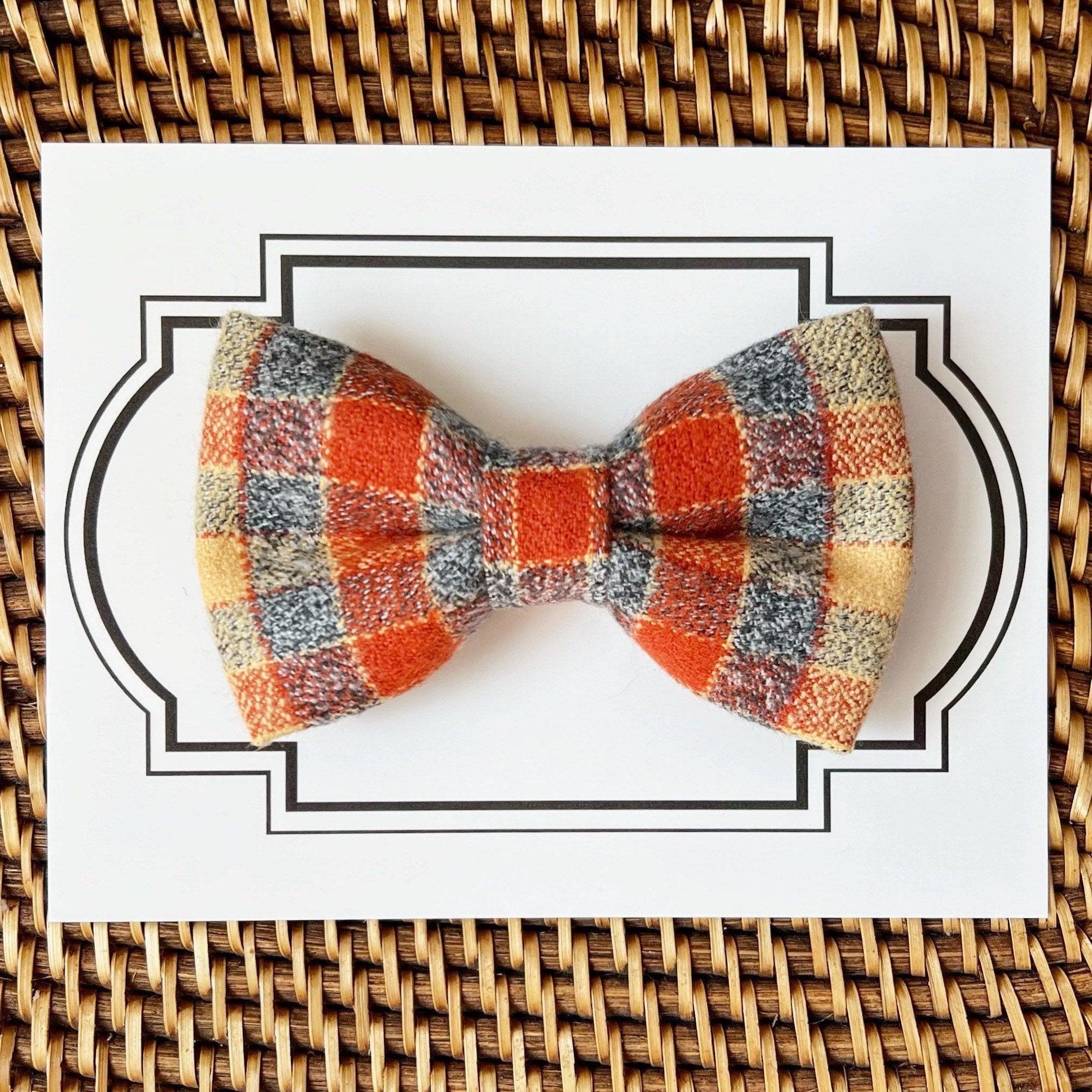 Orange gray plaid bow tie from the Thanksgiving gift set placed on a decorative bordered card in a wicker basket