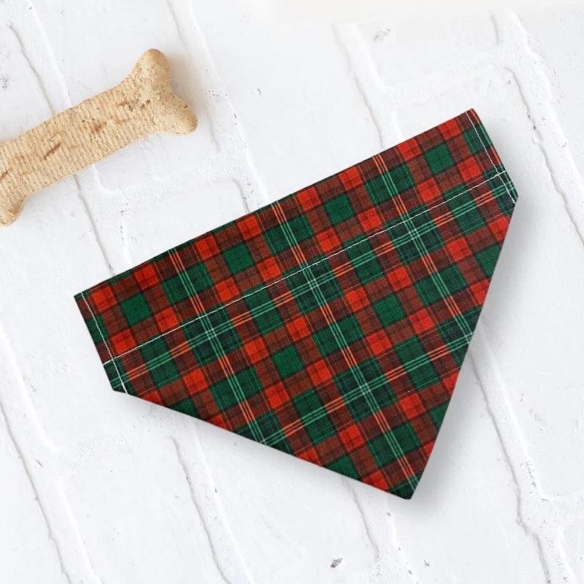 a red and green plaid dog bandana next to a bone bone
