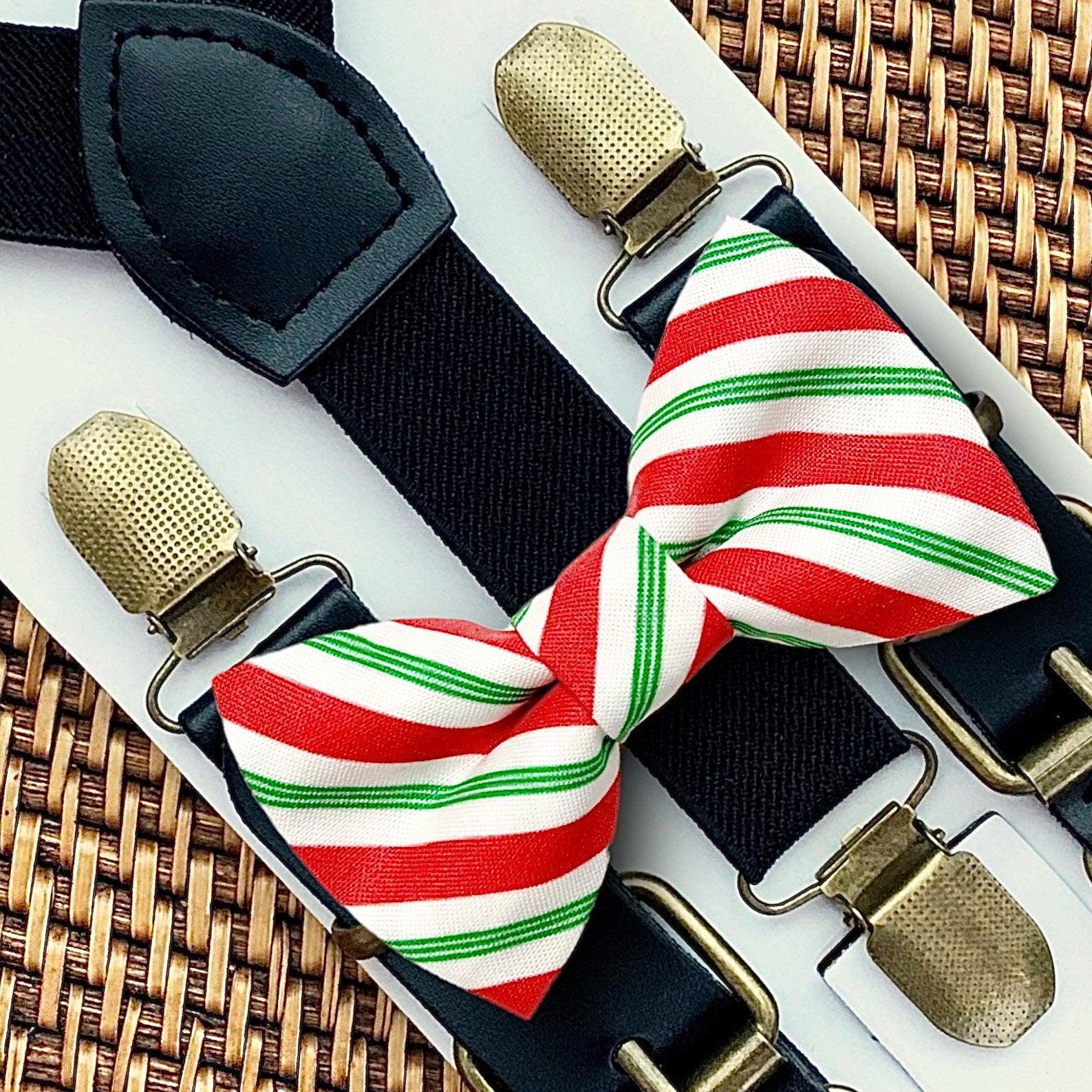Christmas bow tie with Red, white, and stripes with black suspenders and gold clips on a woven surface.