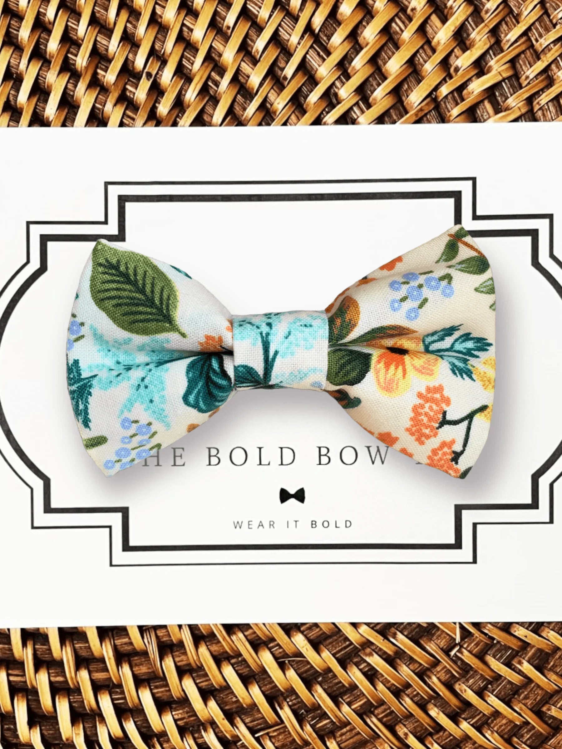 Blue floral bow tie on white packaging with a bold framed border