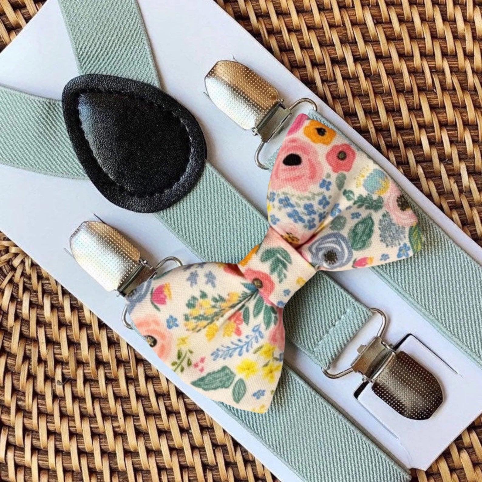 Floral bow tie and Sage suspenders on a woven surface