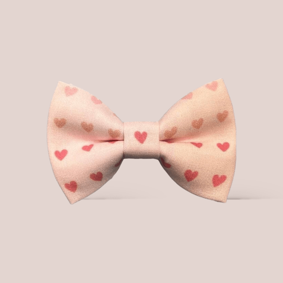 Pink Valentine’s Day hair bow with heart patterns on a light gray background