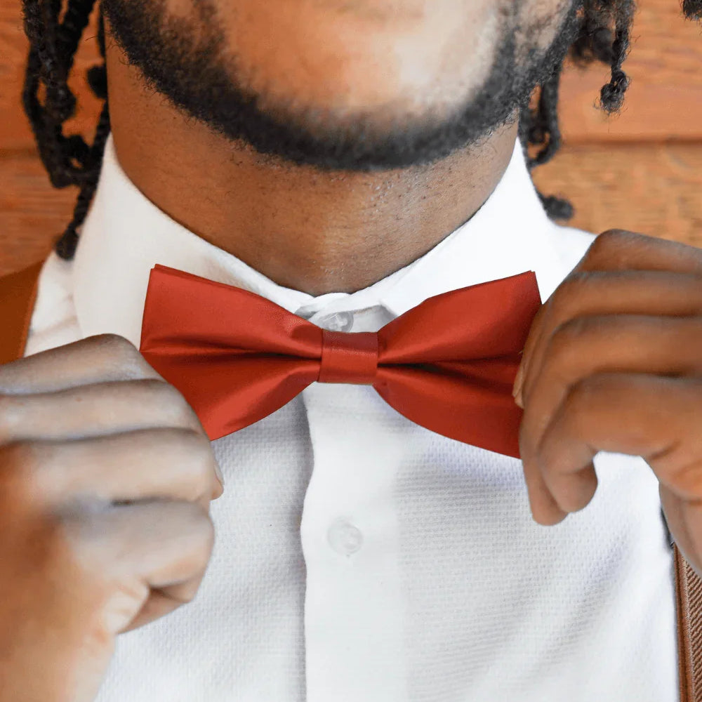 Groomsman in burnt orange rust bow tie and suspenders.