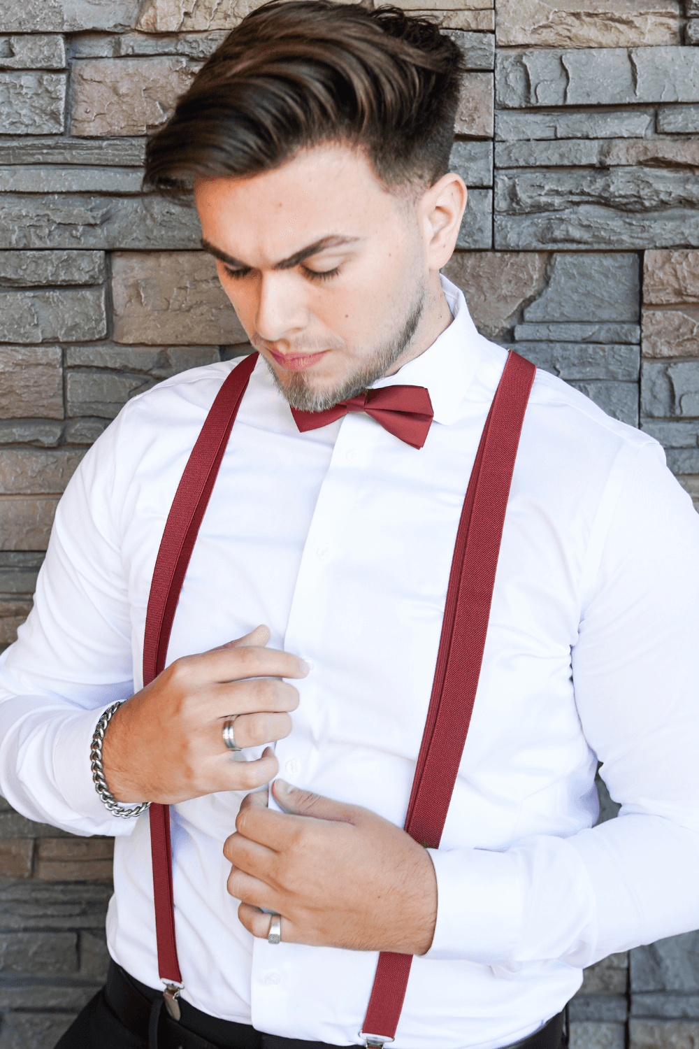 Groomsmen wearing a set of cinnamon suspenders and bow tie for a wedding.