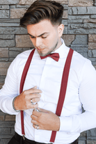 Groomsmen wearing a set of cinnamon suspenders and bow tie for a wedding.