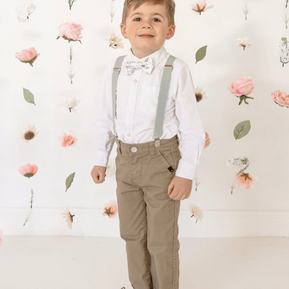 Ring Bearer in Sage green floral bow tie and Sage green suspenders for a wedding.