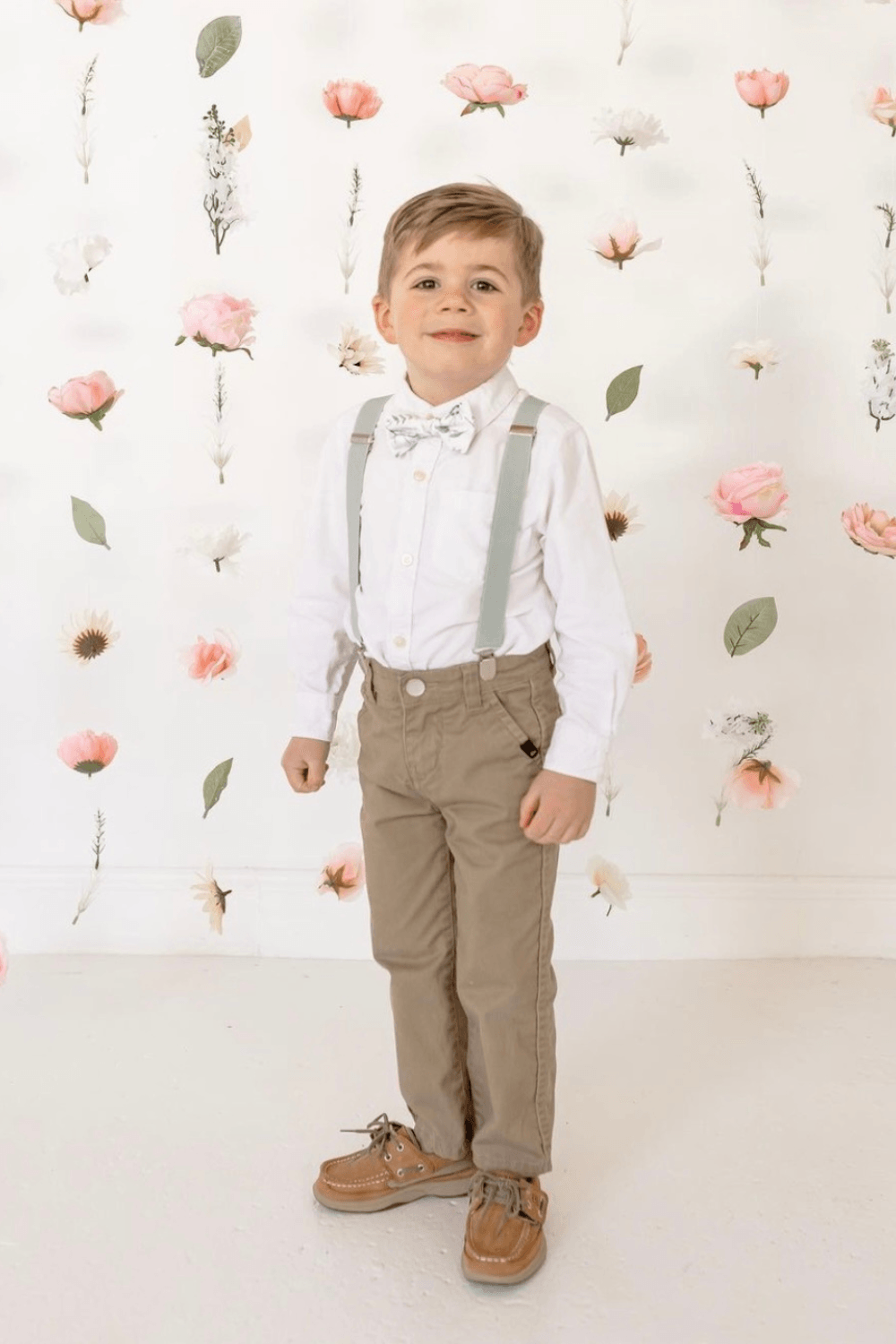 Ring Bearer in Sage green floral bow tie and Sage green suspenders for a wedding.