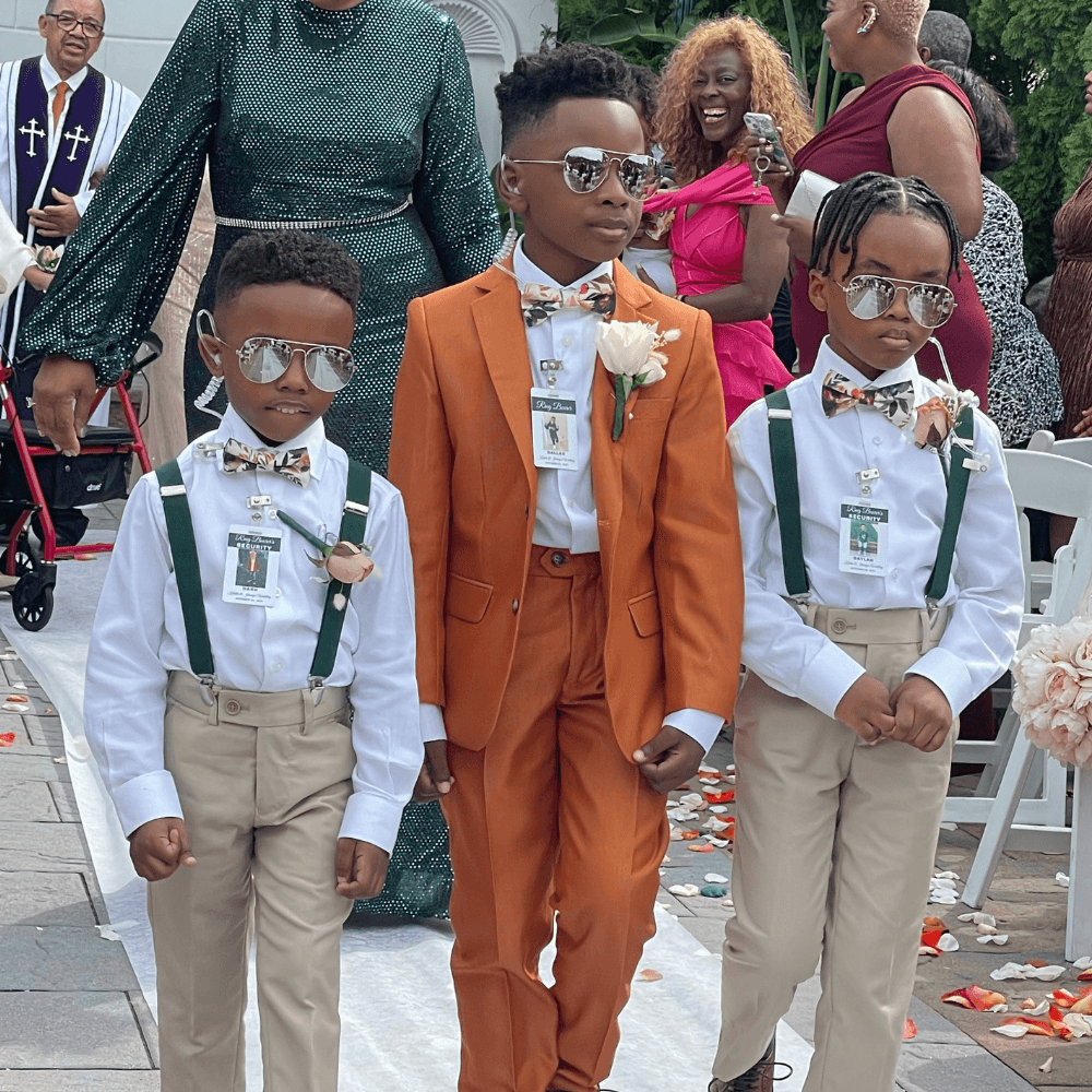 Ring bearers in olive suspenders and floral bow ties in wedding.