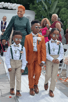Ring bearers in olive suspenders and floral bow ties in wedding.