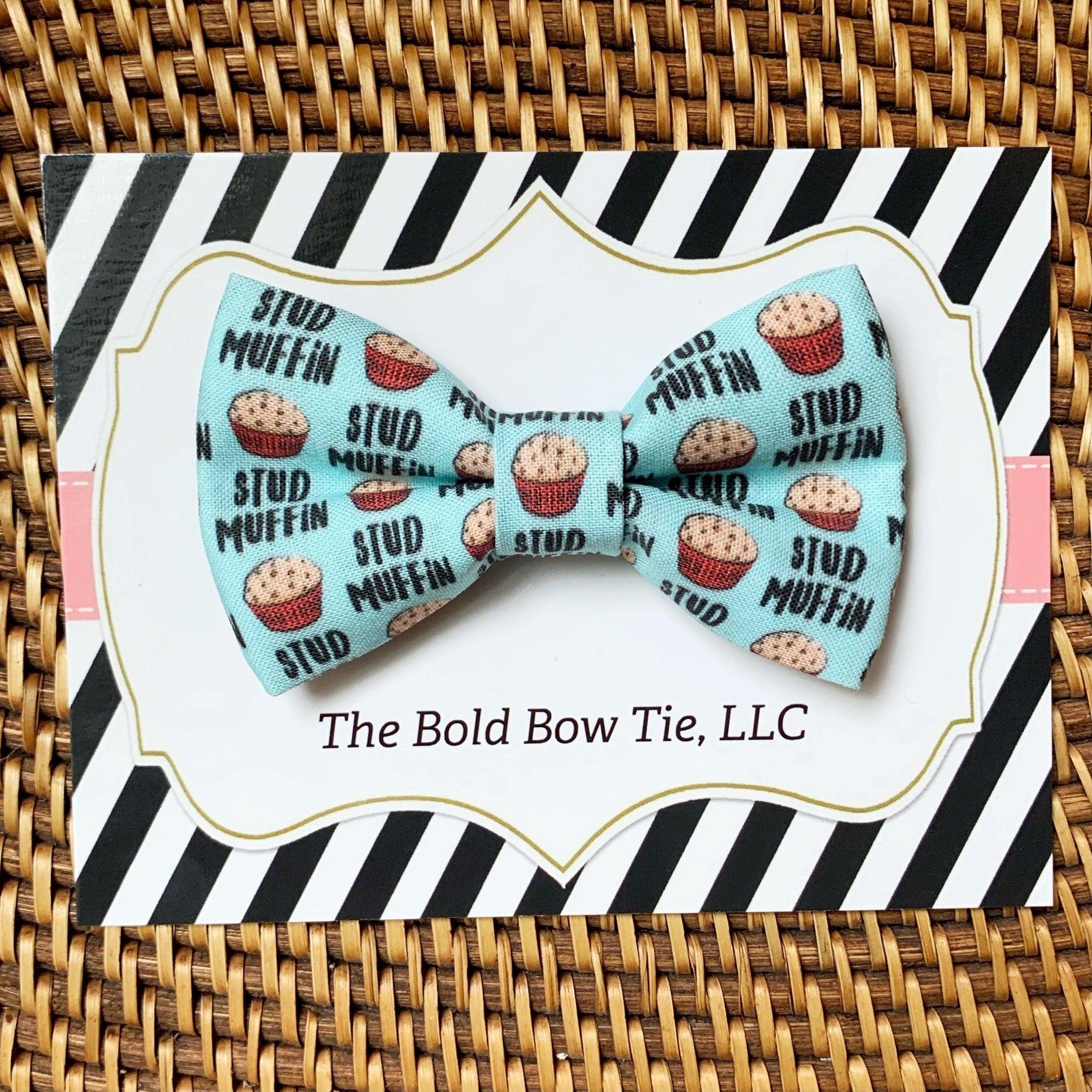 Back view of a red and black plaid bow tie on a wooden surface.