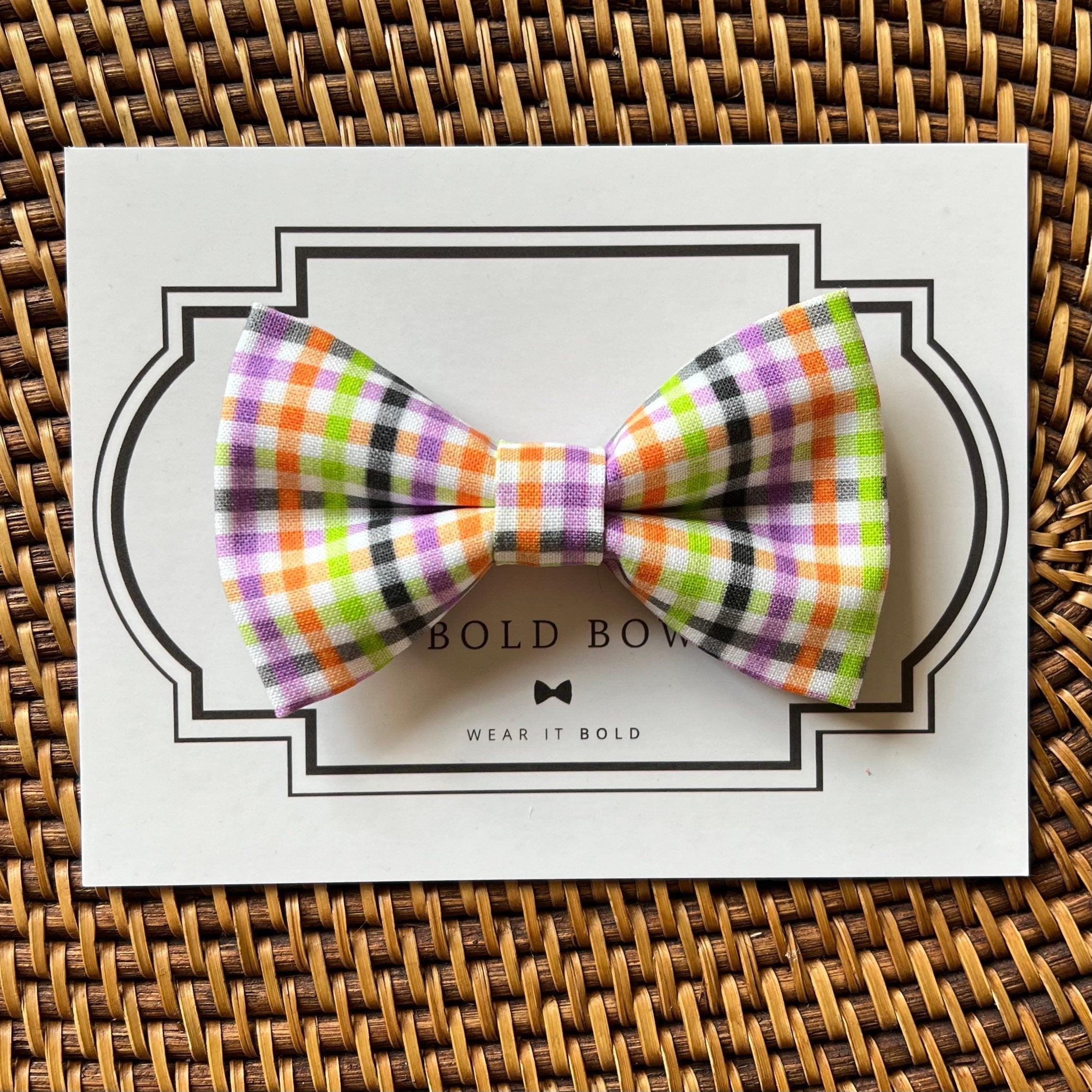 Colorful plaid bow tie on white card with bold border, over a woven basket background.