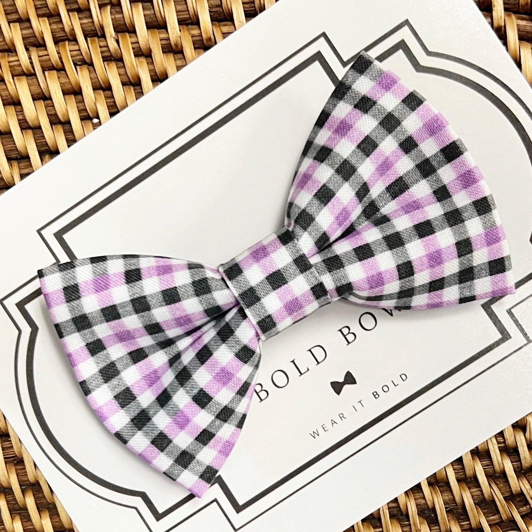 Size chart for pre-tied bow ties from The Bold Bow Tie detailing measurements across three sizes. Small is 3.5 inches wide and recommended for ages 6 months to 5 years. Medium is 4 inches wide and recommended for ages 6 to 12 years. Large is 4.5 inches wide and recommended for ages 13 years and up. Visual icons illustrate the relative sizes with horizontal arrows showing that width is measured from wingtip to wingtip. Bottom text notes that all bow ties are pre-tied and ready to add to your outfit.
