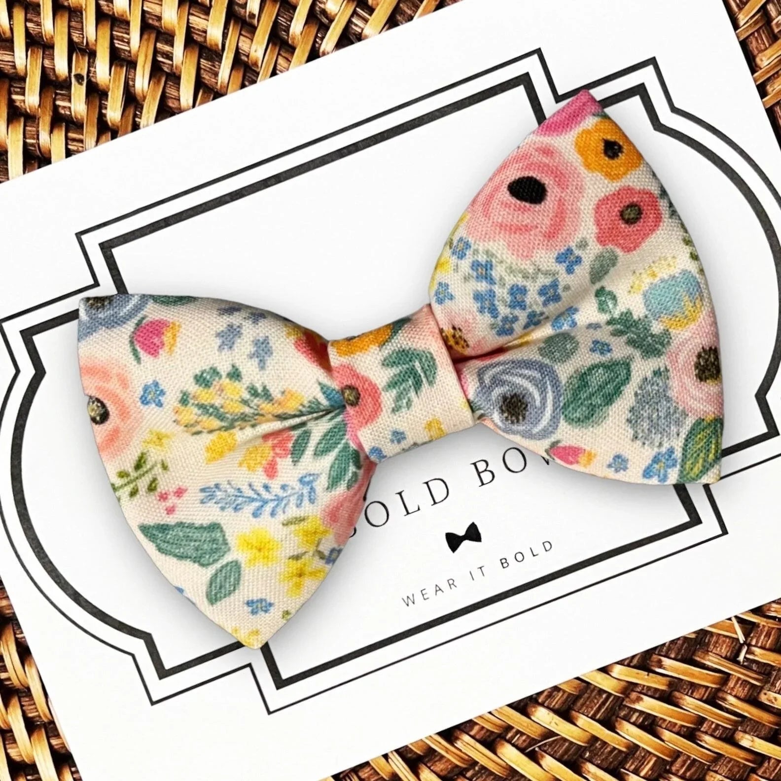 Floral dog bowtie on a decorative card from The Bold Bow Tie.