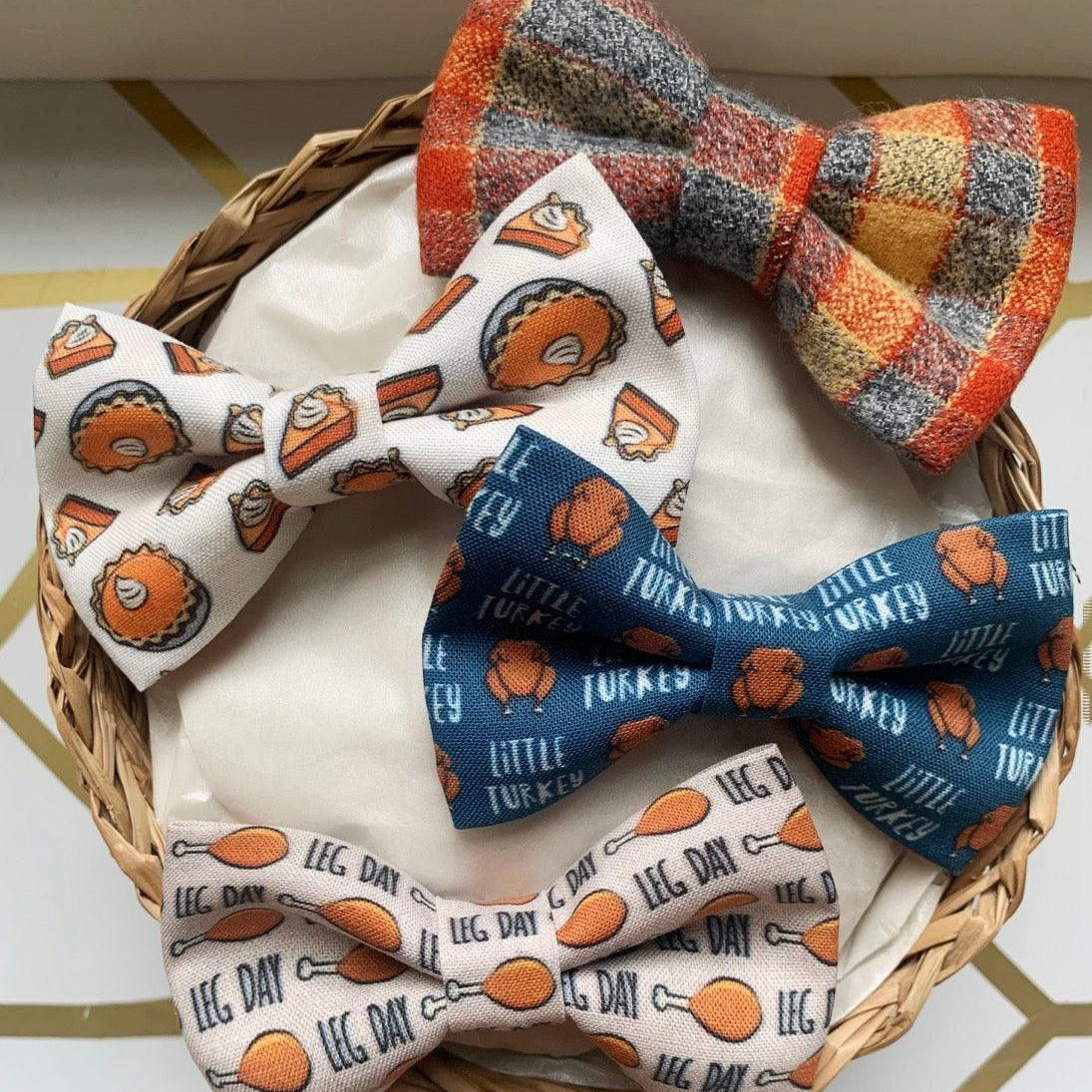Gift set of plaid and printed bow ties arranged in a wicker basket on a white card with a border