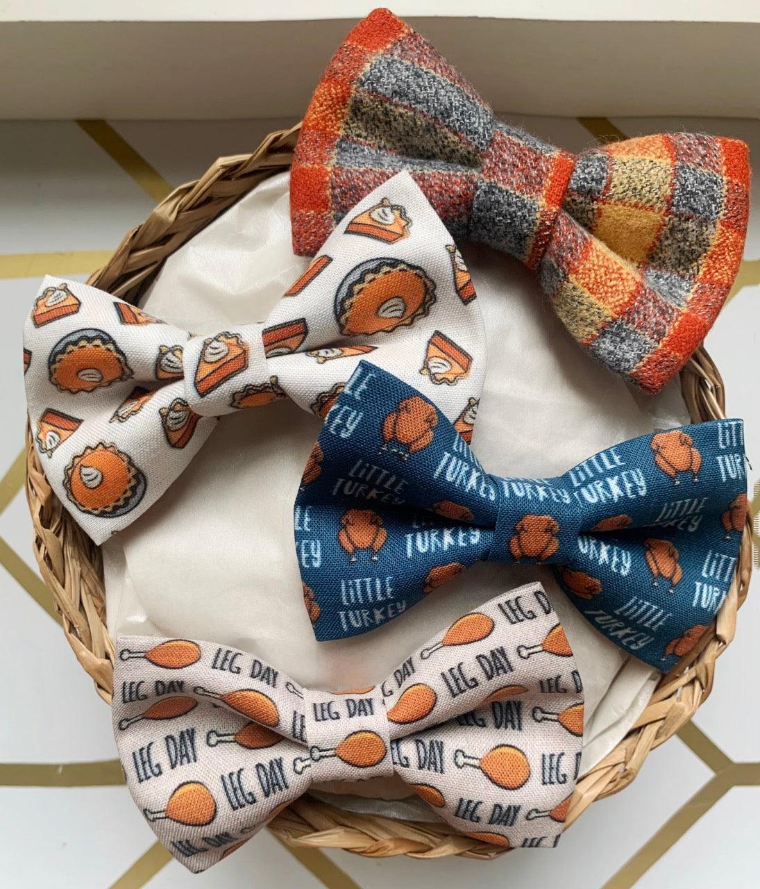Gift set of plaid and printed bow ties arranged in a wicker basket on a white card with a border